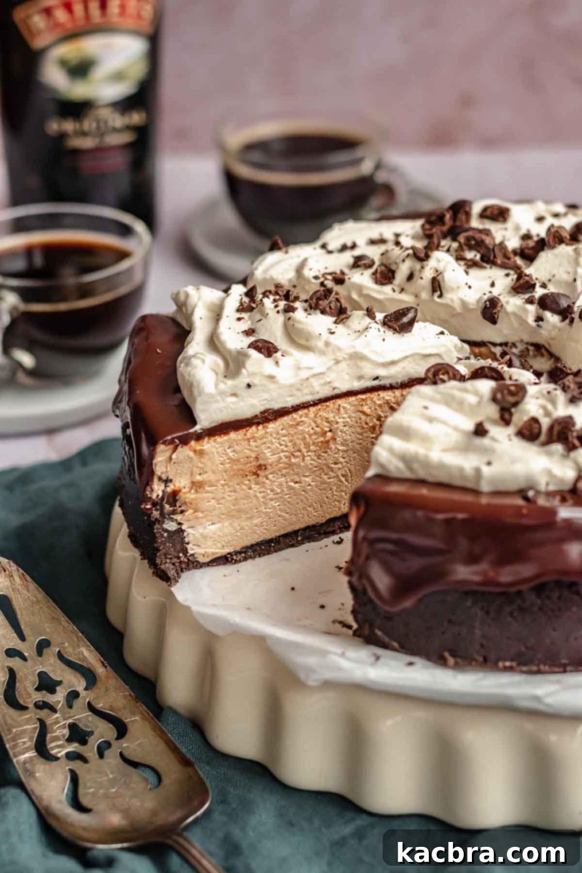 A large slice of rich Baileys chocolate cheesecake being carefully pulled away from the main cake, showcasing its smooth layers and thick crust.