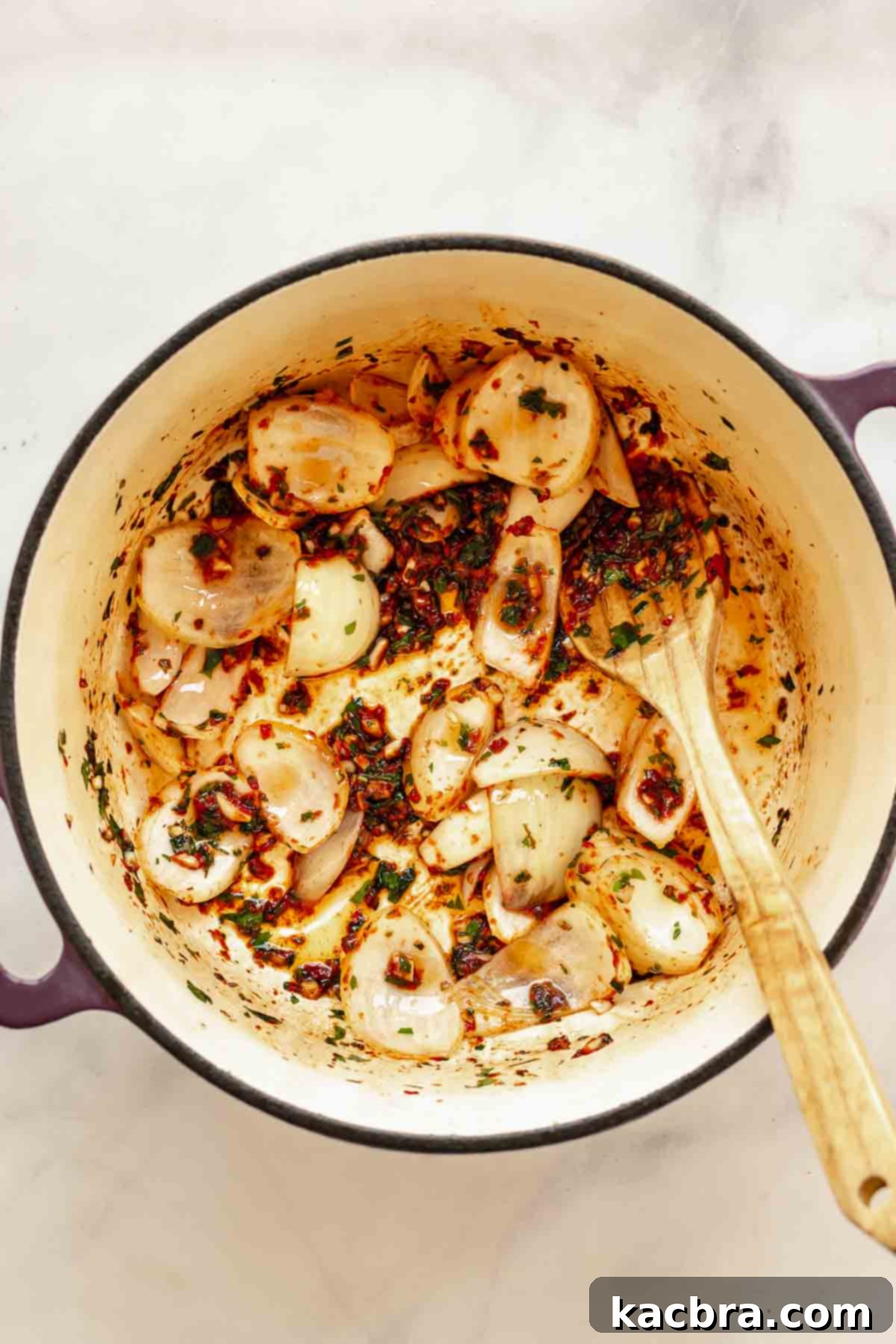 Onions, herbs, and tomato paste cooking in a pot.