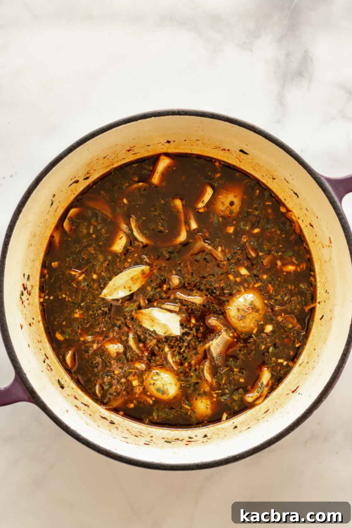 Vegetables, beef and beef stock in a pot.