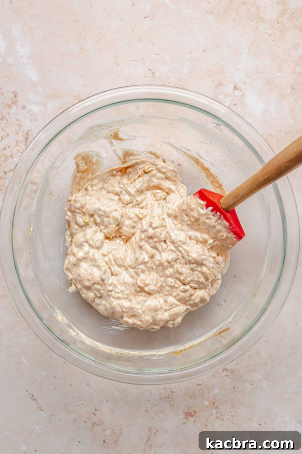 Seasonings, mayo, relish, and ketchup mixed into cream cheese in a bowl.