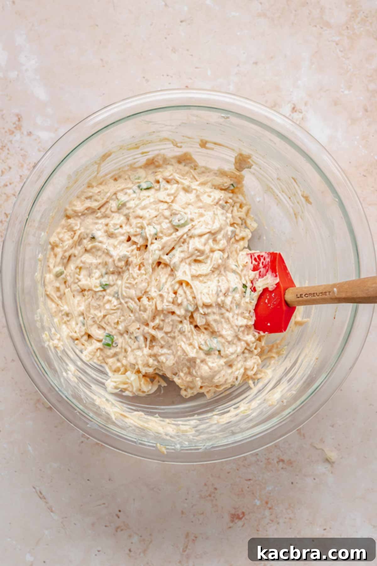 Cheese and scallions mixed into the dip in a bowl.
