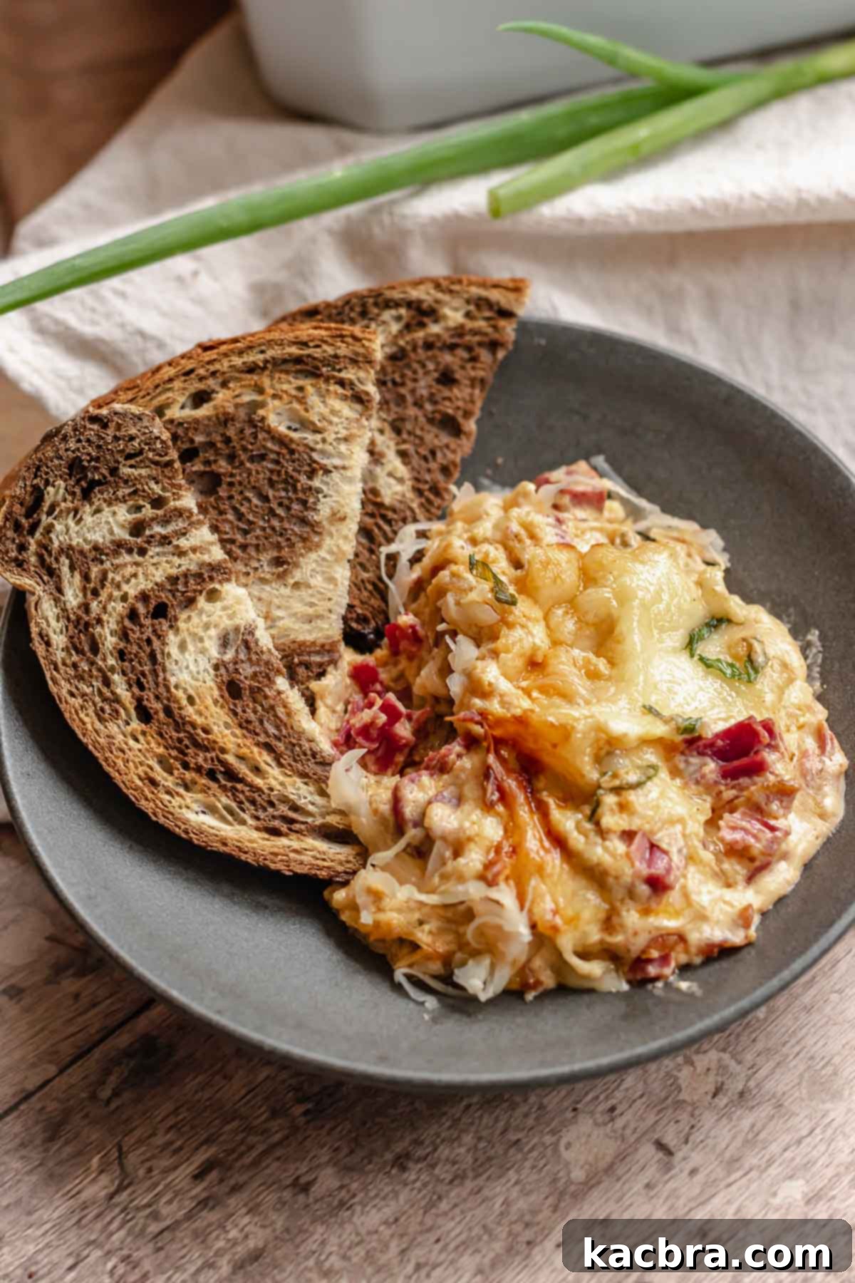 Slices of bread and reuben dip on a plate.