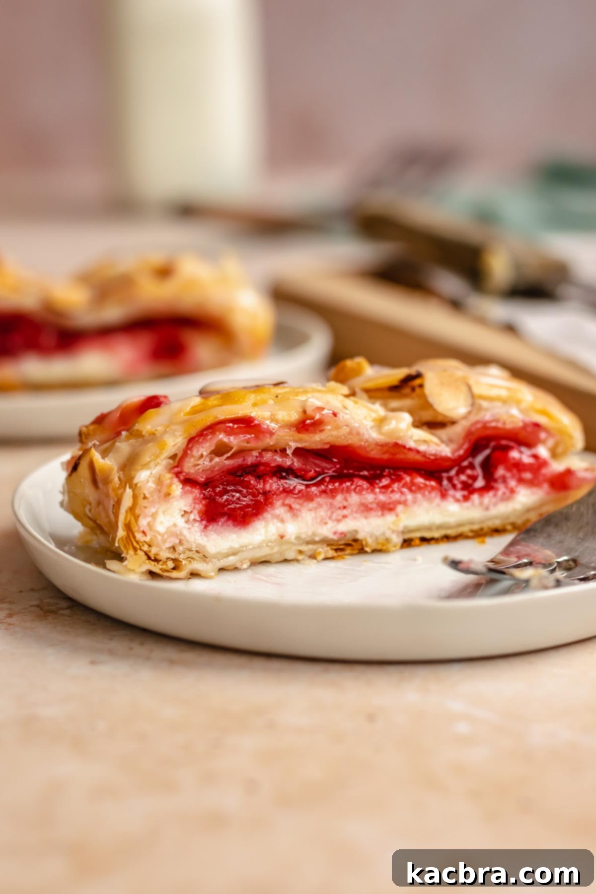 Flaky Cherry Cream Cheese Pastry 14 A perfectly sliced piece of cream cheese danish resting on a white plate, ready to be enjoyed.