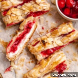 Sliced cherry danish on a cutting board.