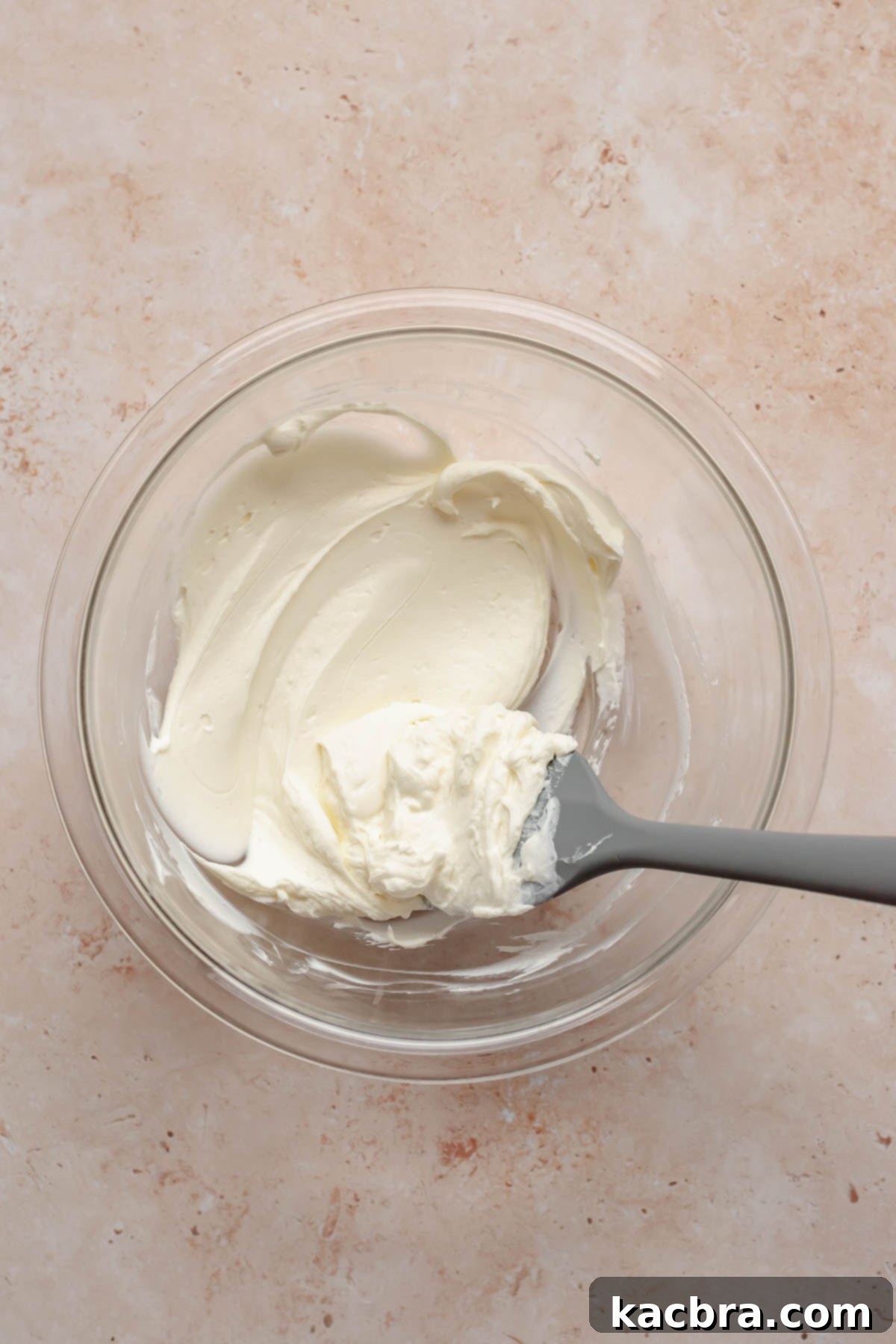 Softened cream cheese, powdered sugar, and almond extract in a bowl, ready to be mixed.