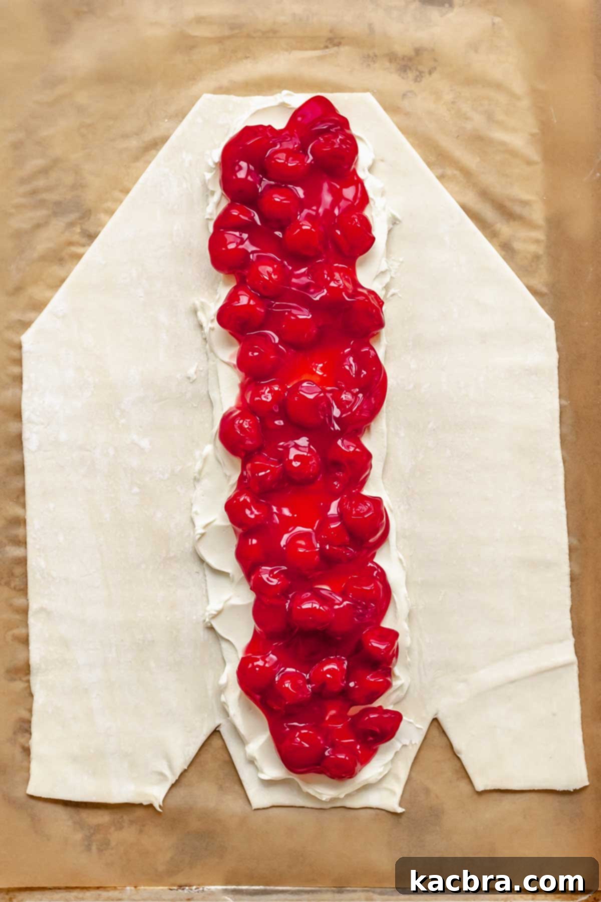 Flaky Cherry Cream Cheese Pastry 7 Cream cheese filling and cherry pie filling are carefully spread down the center of the puff pastry strip.