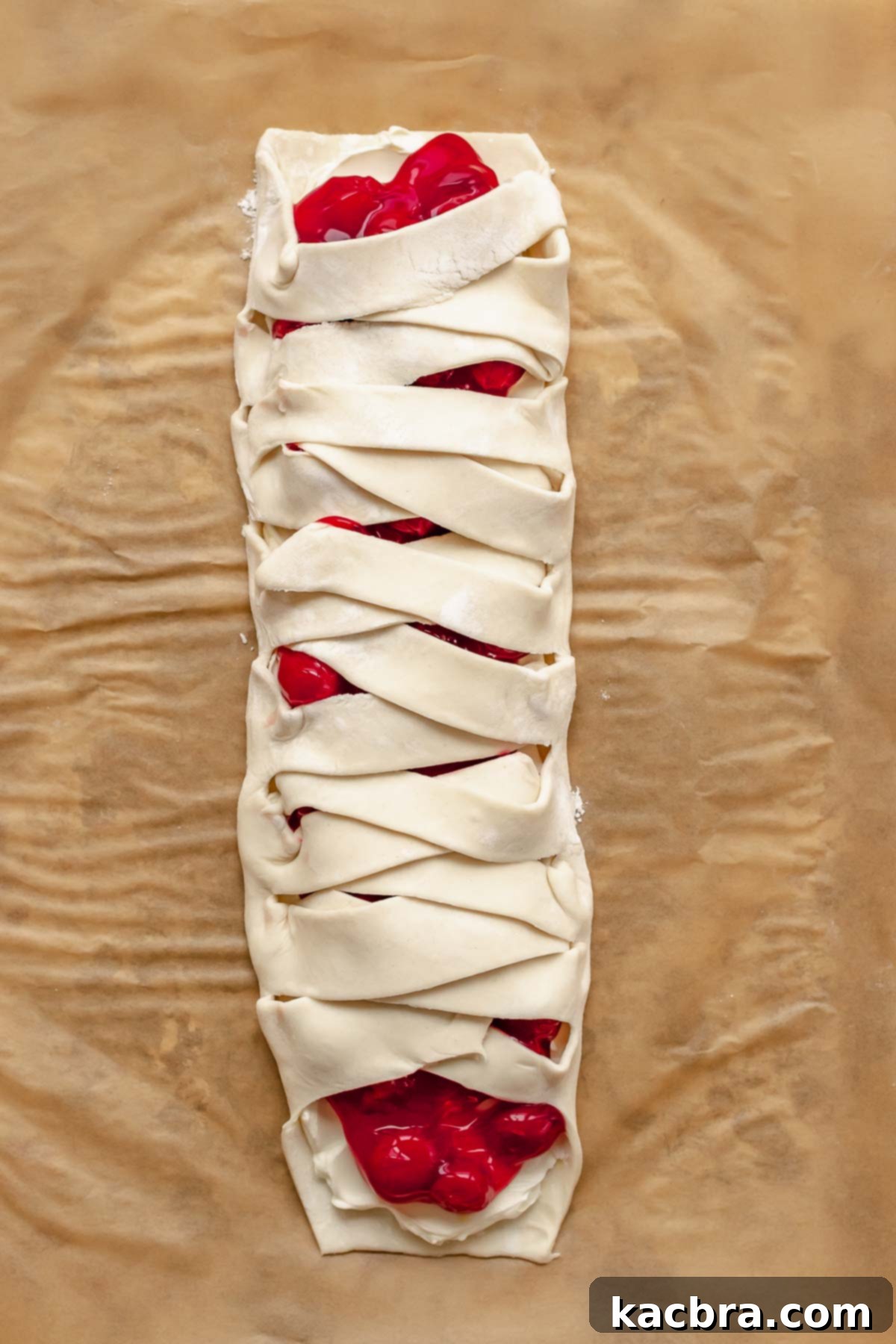 Pieces of puff pastry criss-crossed over each other to cover the filling, forming a braid.