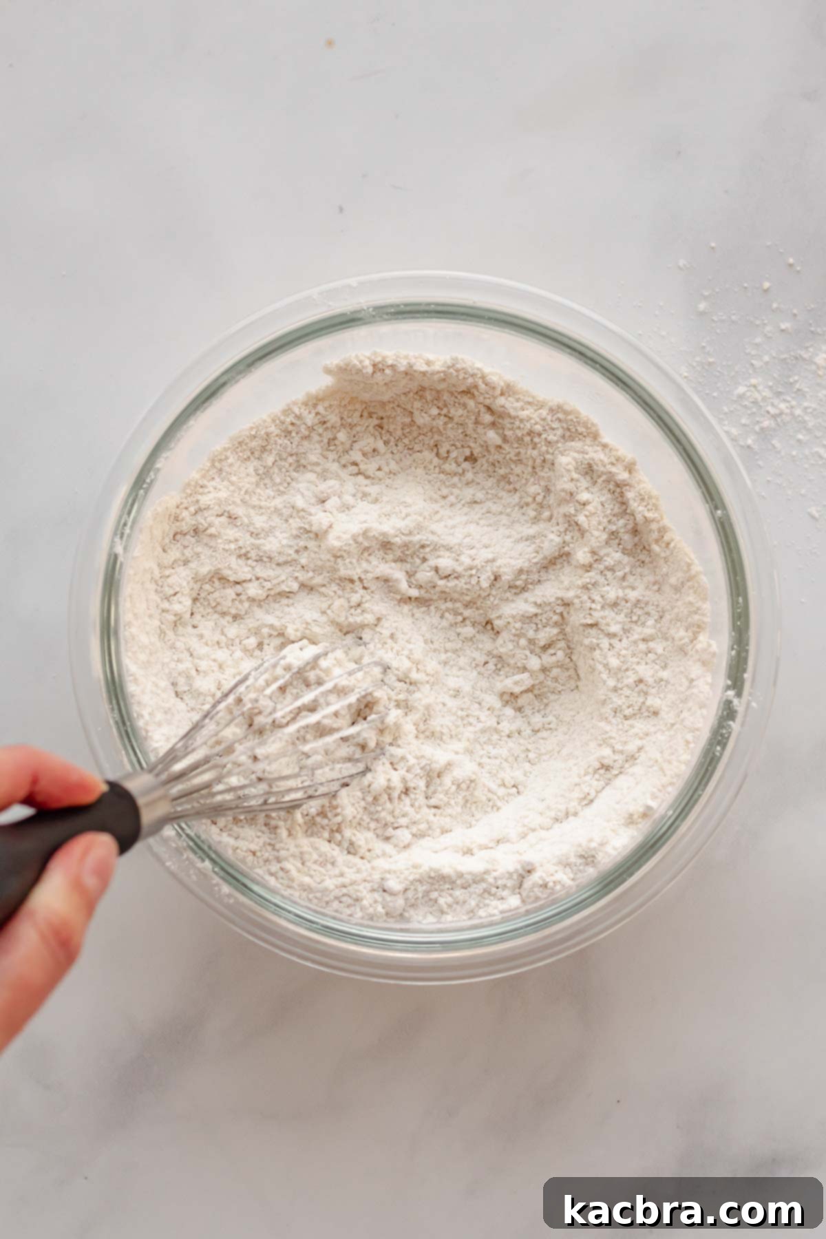 Crimson Kissed Almond Delight 5 Dry ingredients being whisked together in a mixing bowl.