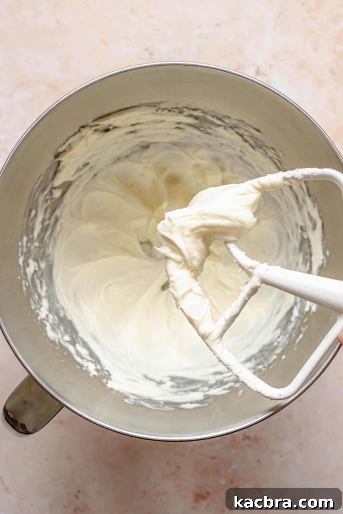 Crimson Kissed Almond Delight 10 Creamed cream cheese, powdered sugar, and almond extract in a bowl, ready for whipping.