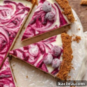 Slices of a decadent white chocolate tart topped with sugared cranberries on a serving platter, ready for guests.