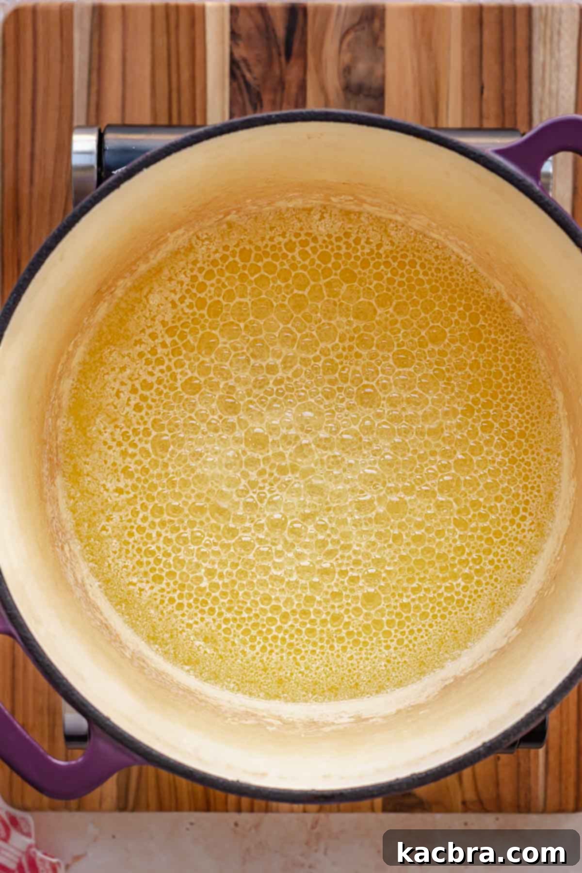 Butter melted and browning slightly in a pot, with small tan specs at the bottom.