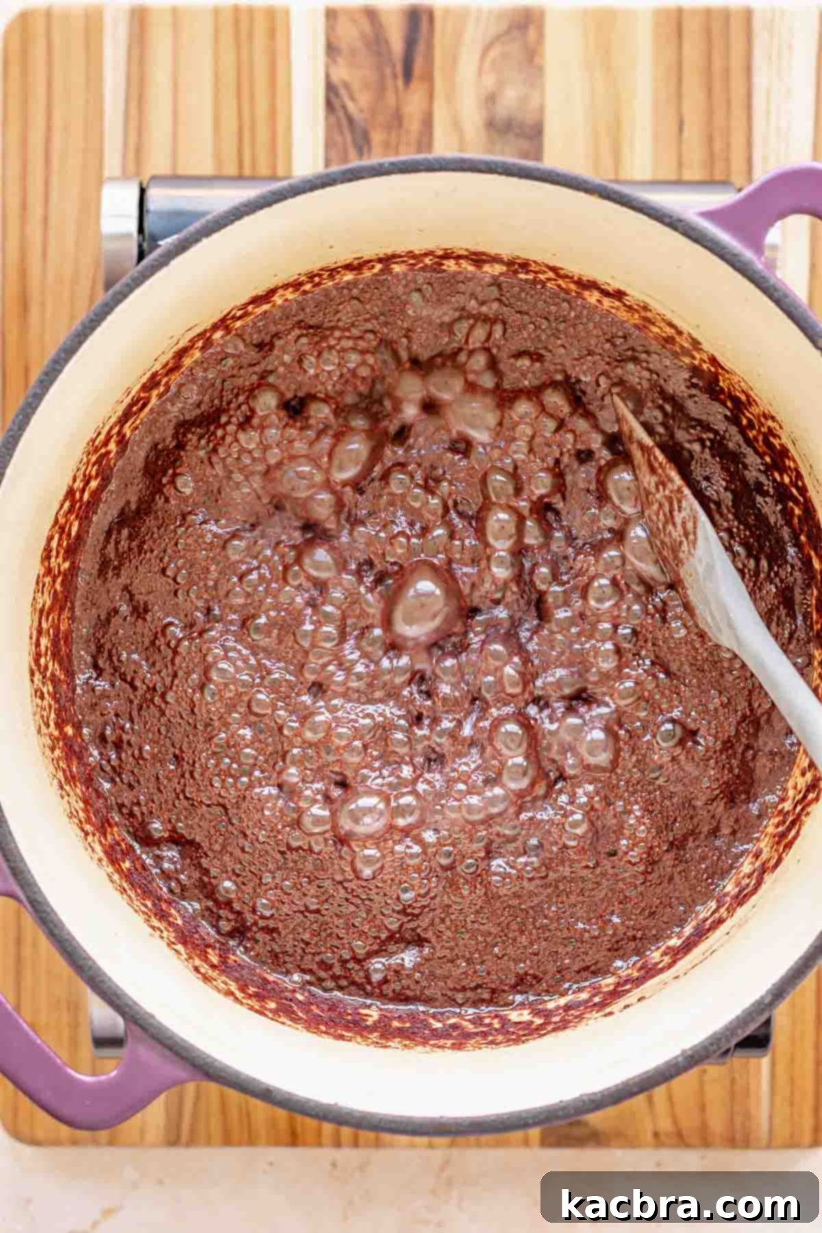 Chocolate mixture bubbling gently in a pot on the stovetop.