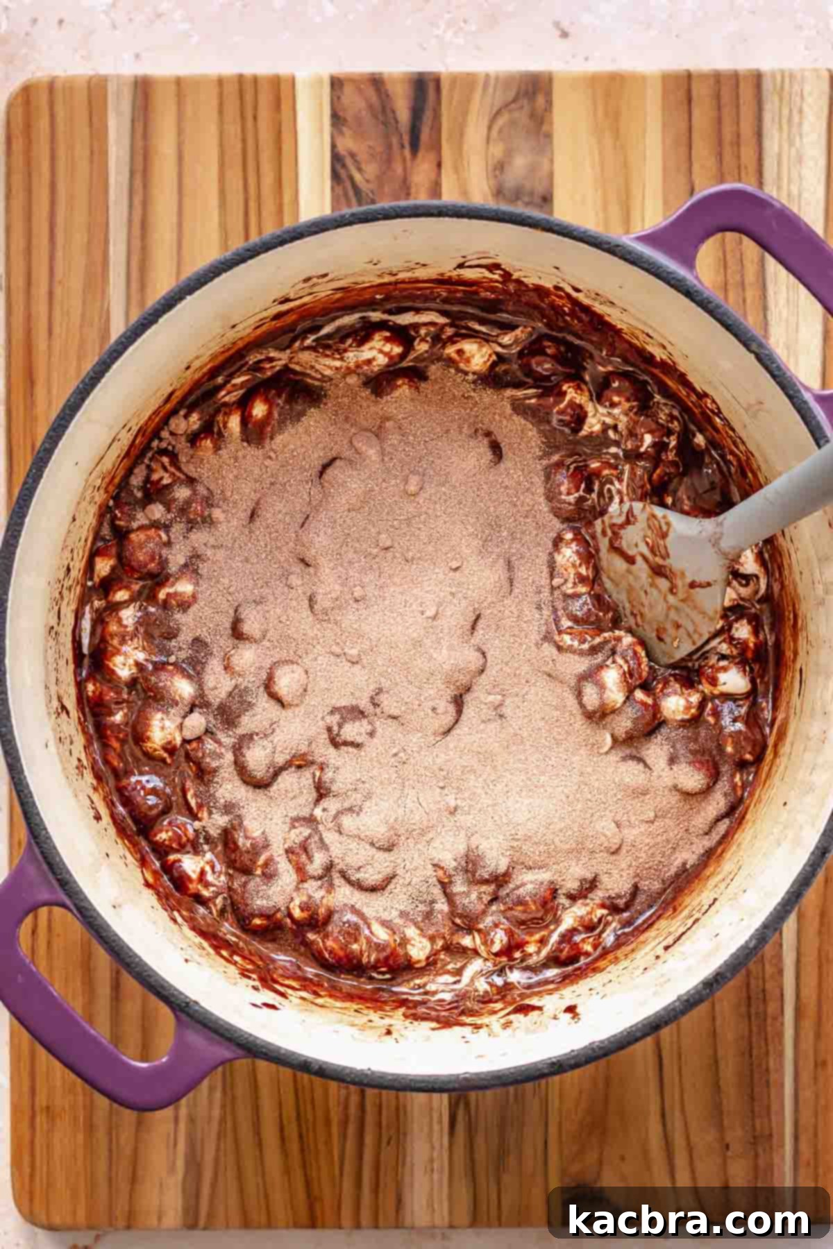 Remaining marshmallows, chocolate chips, and malted milk powder being added to the warm chocolate mixture.
