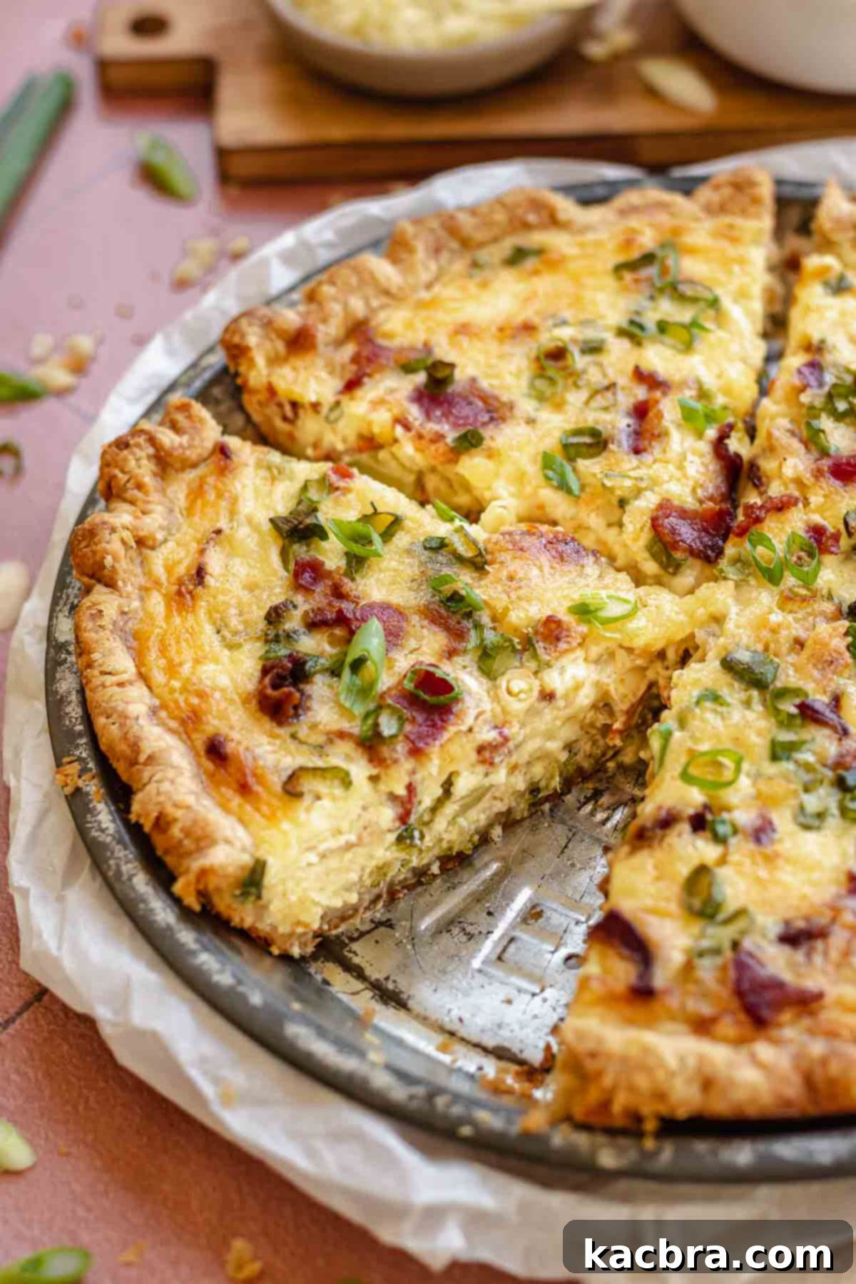 Broccoli bacon quiche sliced in a pie dish, ready to be served.