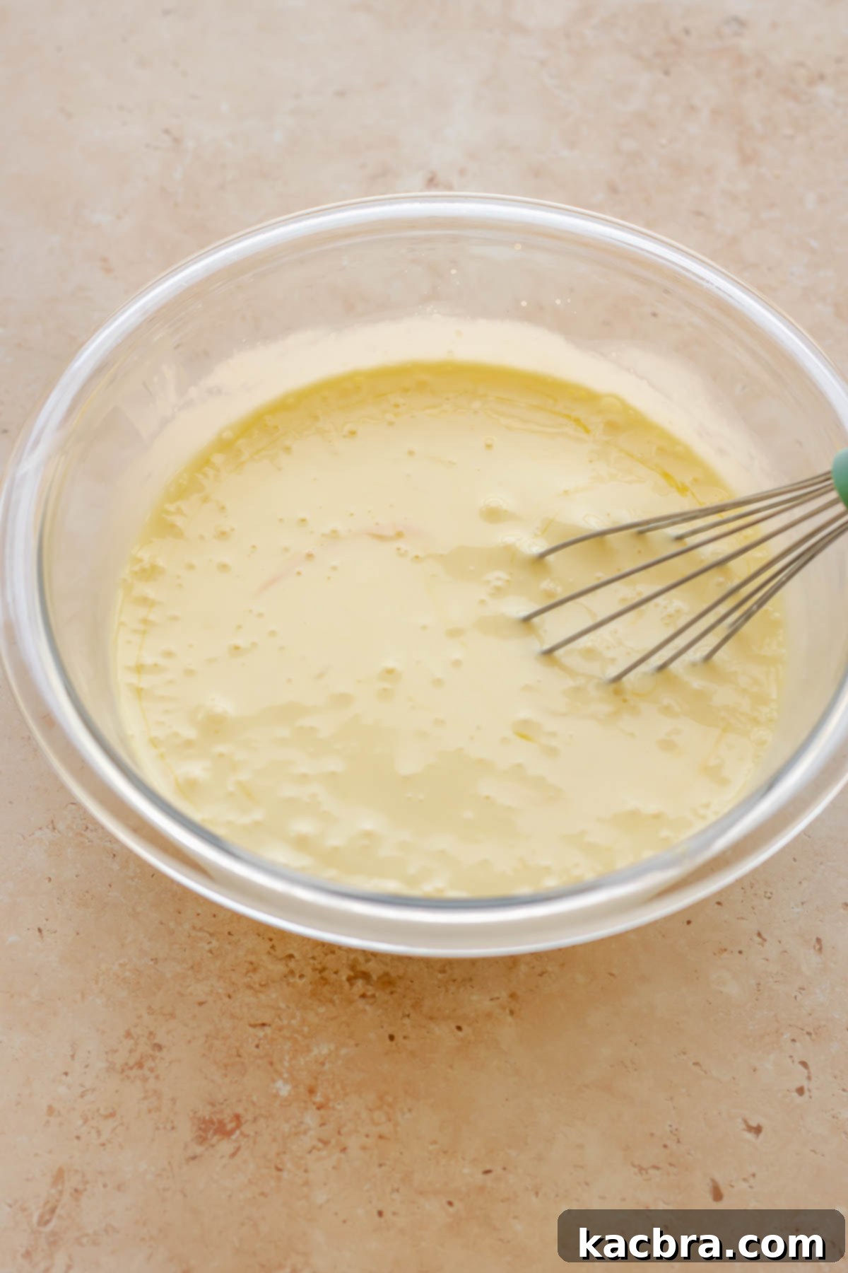 Egg custard mixture, whisked until smooth, in a mixing bowl.