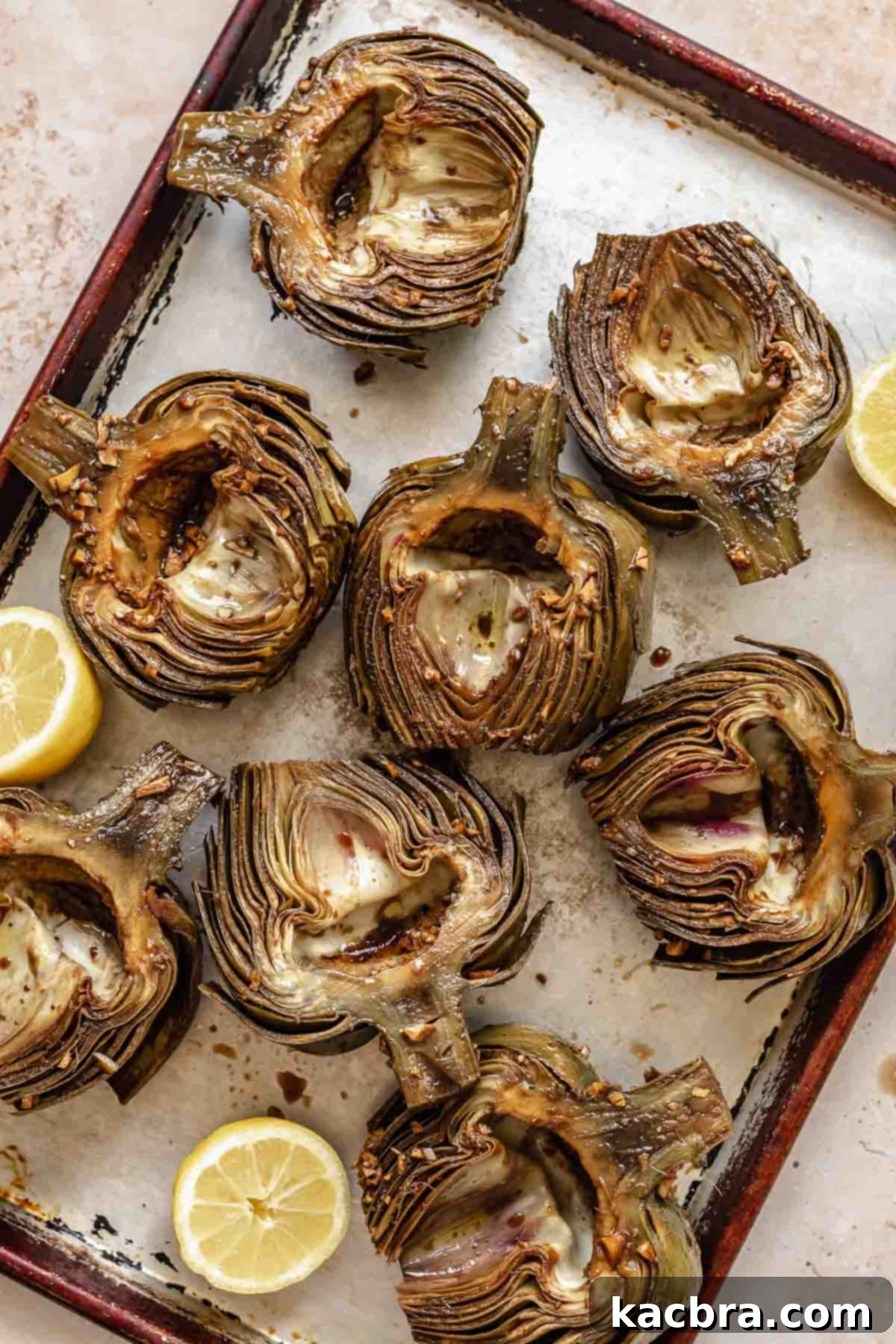Marinated artichoke halves on a cookie sheet.