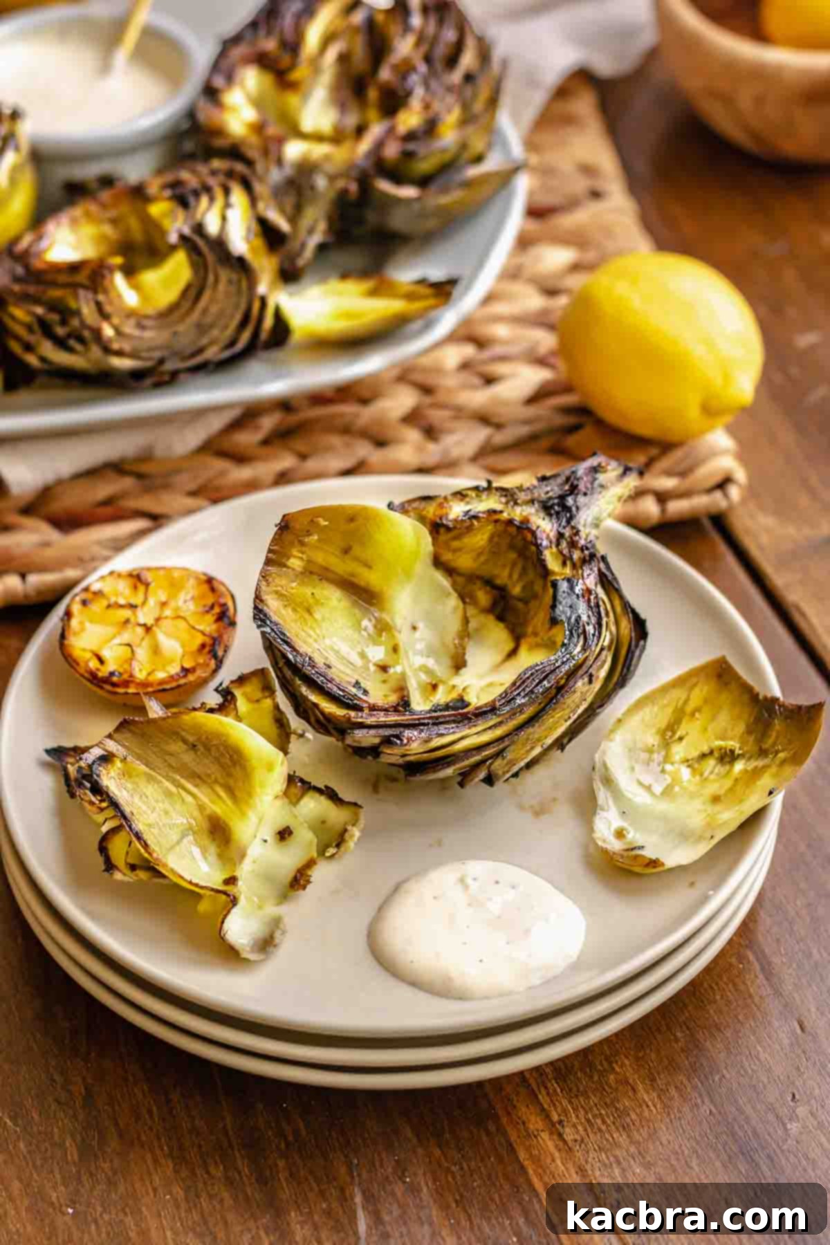 Half a grilled artichoke on a plate with leaves removed.