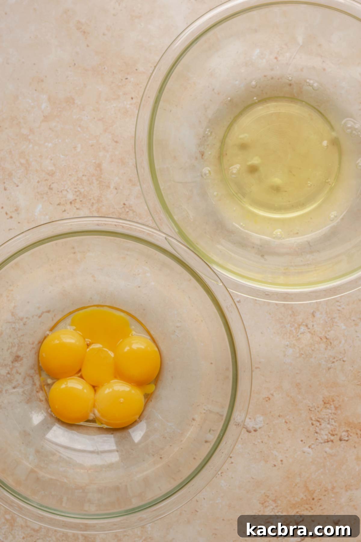 Egg yolks and egg whites in separate bowls, ready for whipping.