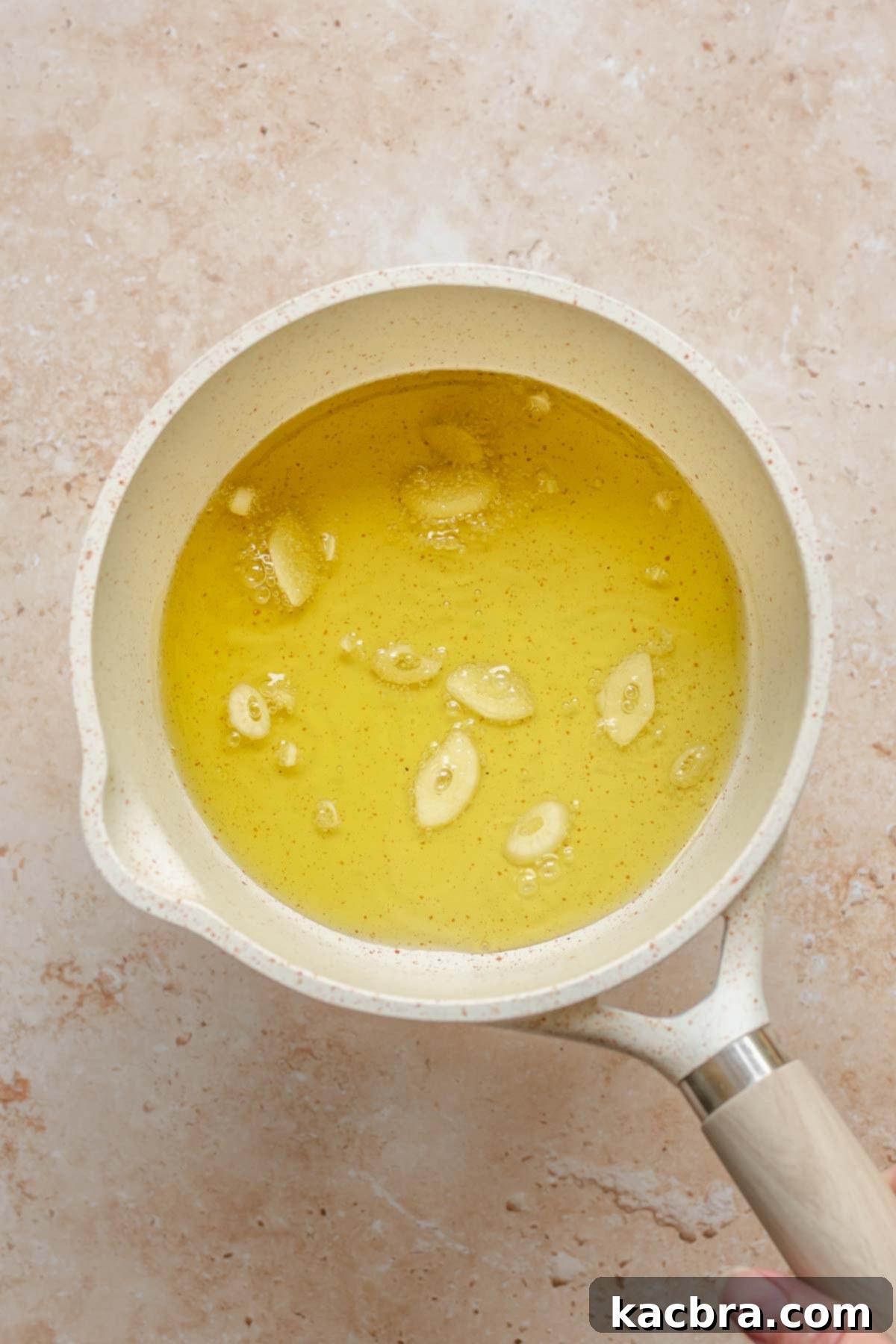 Fresh Burrata Caprese Drizzled with Aromatic Garlic Basil Oil 4 Garlic cloves simmering in olive oil.