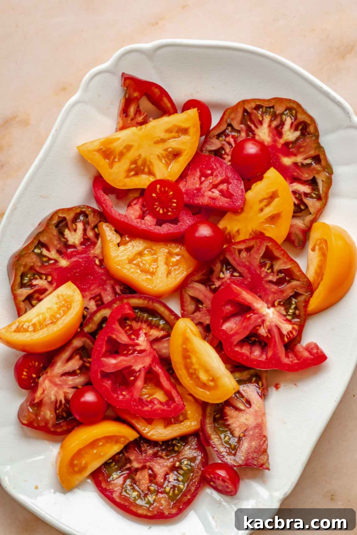 Fresh Burrata Caprese Drizzled with Aromatic Garlic Basil Oil 6 Sliced tomatoes arranged on a platter.