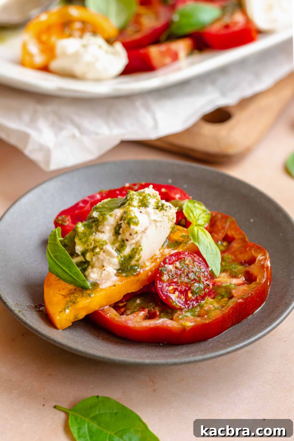 Fresh Burrata Caprese Drizzled with Aromatic Garlic Basil Oil 10 Burrata caprese salad on a plate.