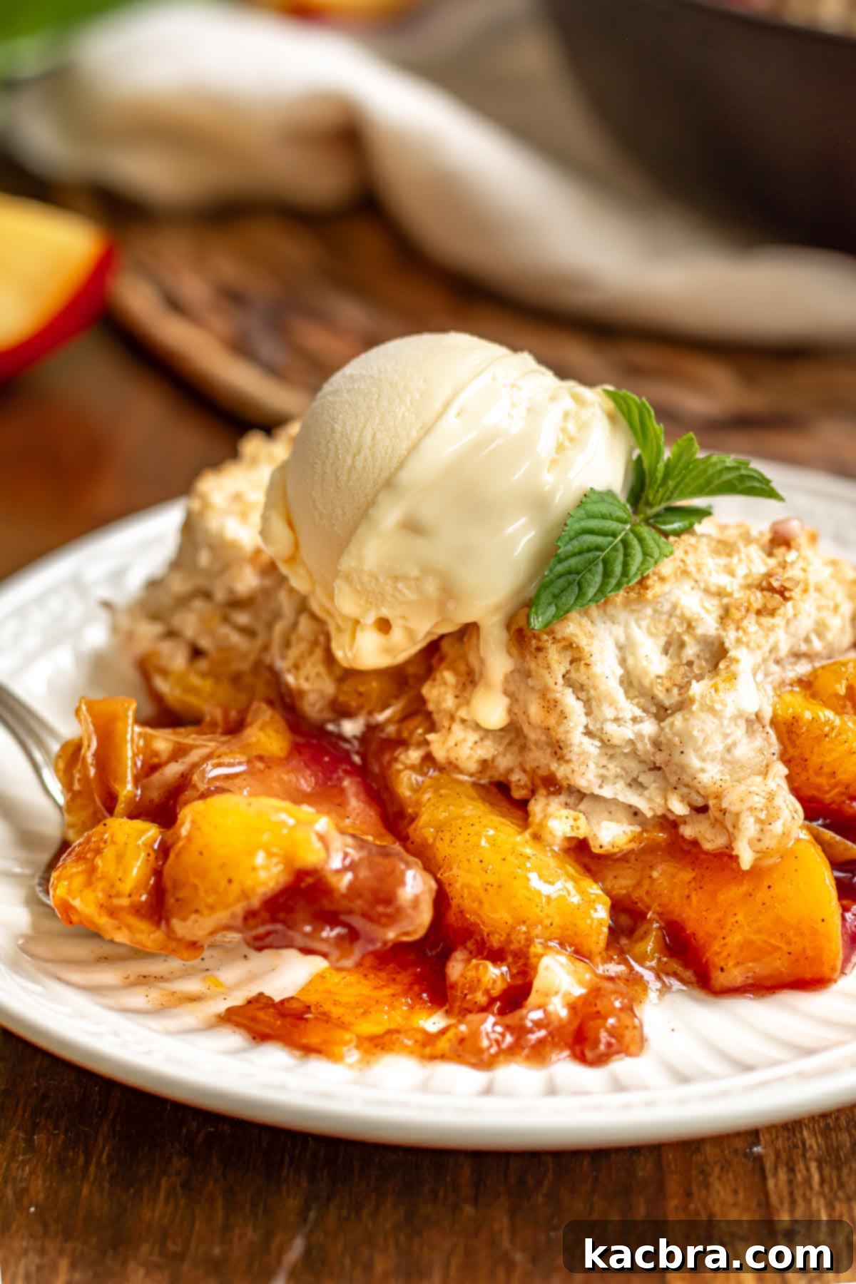 Golden Skillet Peach Cobbler 12 A plate with served peach cobbler topped with ice cream.