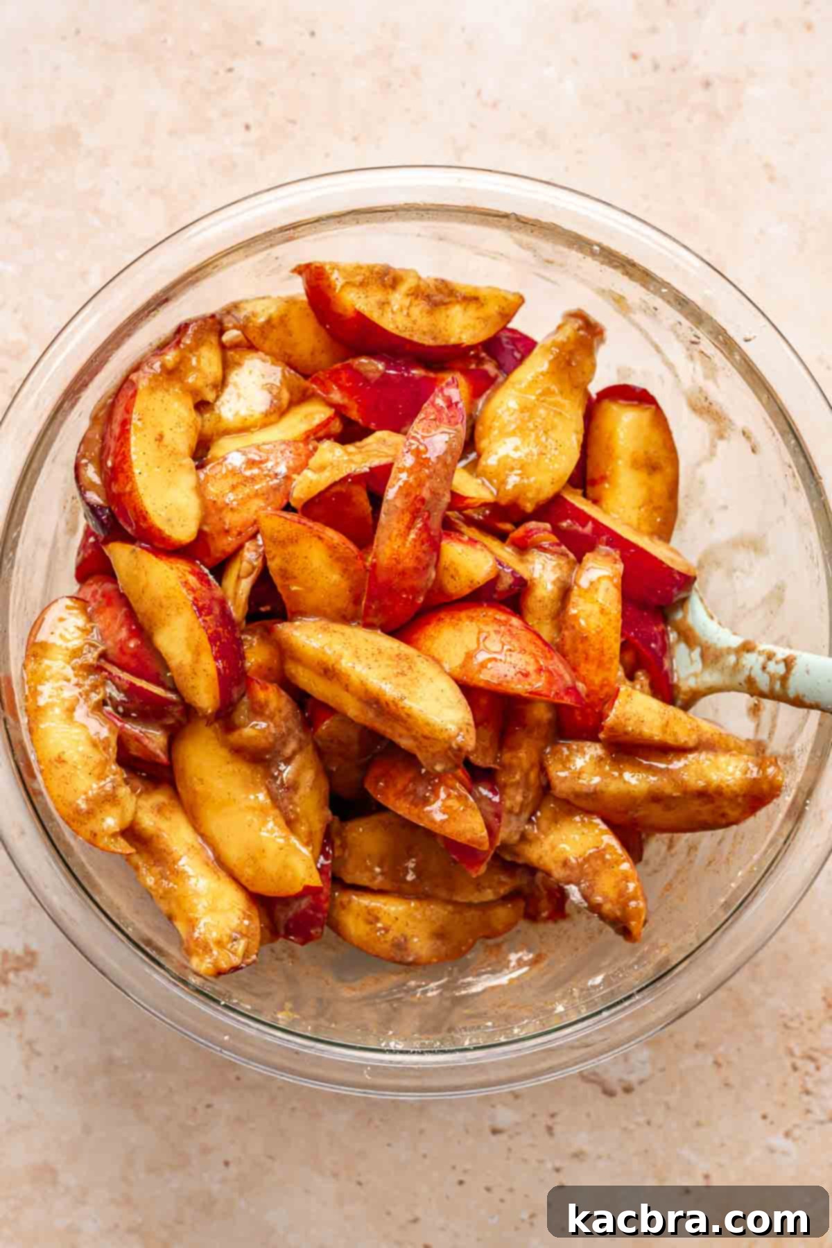 Golden Skillet Peach Cobbler 6 Peaches with spices and sugar in a bowl.