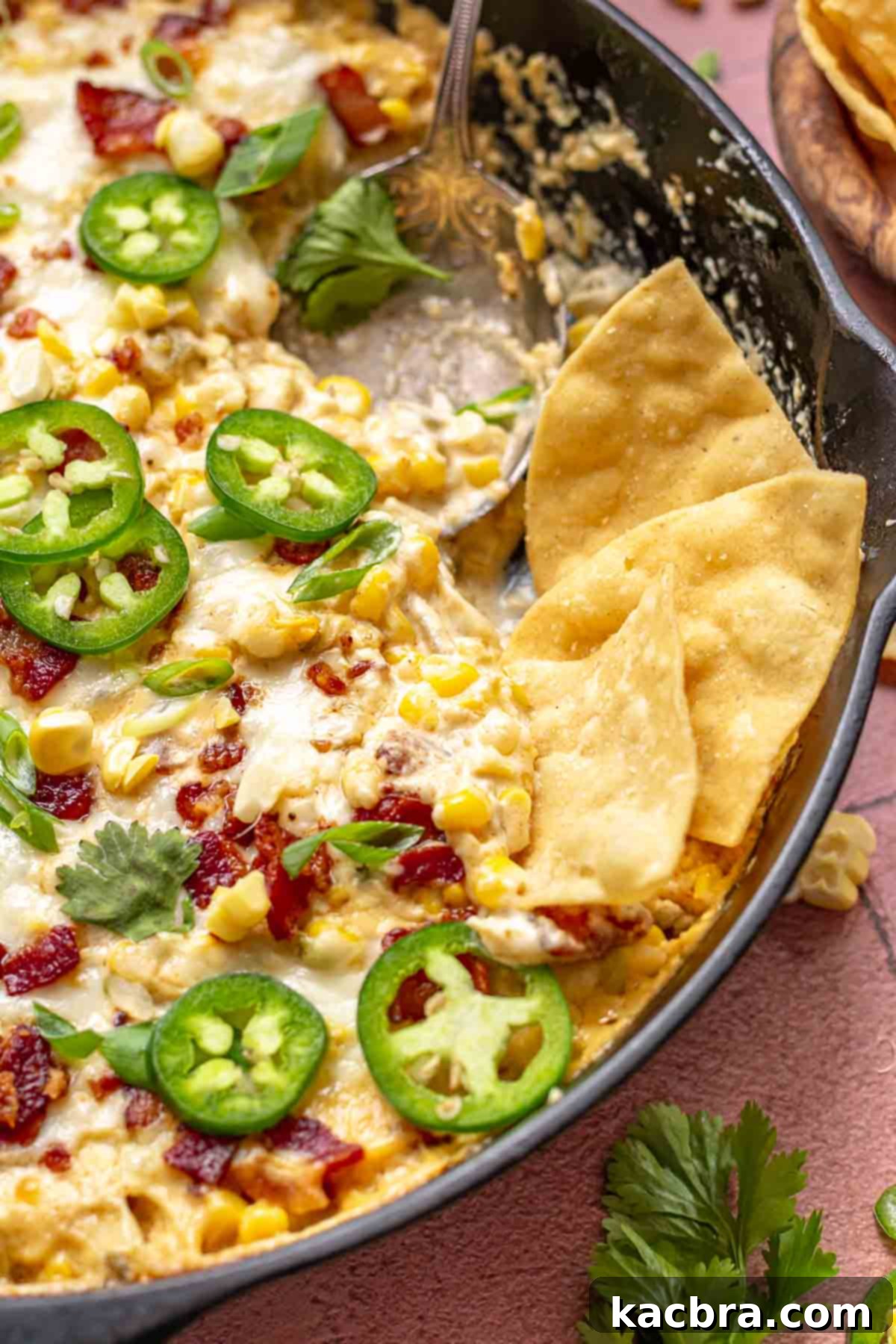 Kickin' Jalapeño Corn Dip 2 Chips in a skillet with spicy corn dip.