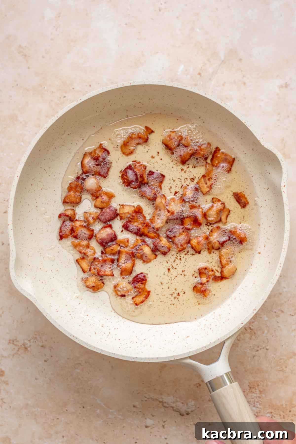 Kickin' Jalapeño Corn Dip 4 Bacon pieces frying in a pan.