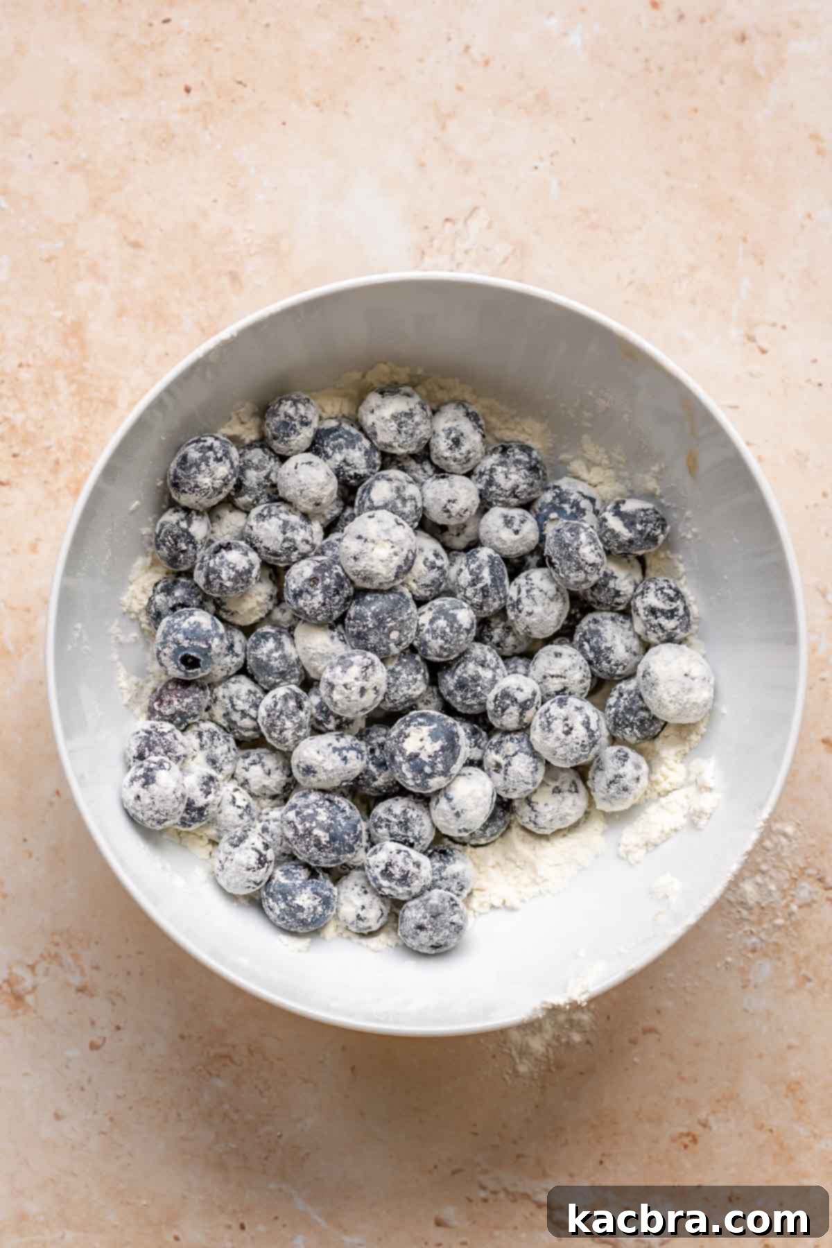 Sweet and Healthy Banana Blueberry Oatmeal Muffins 11 Blueberries coated in flour in a bowl.