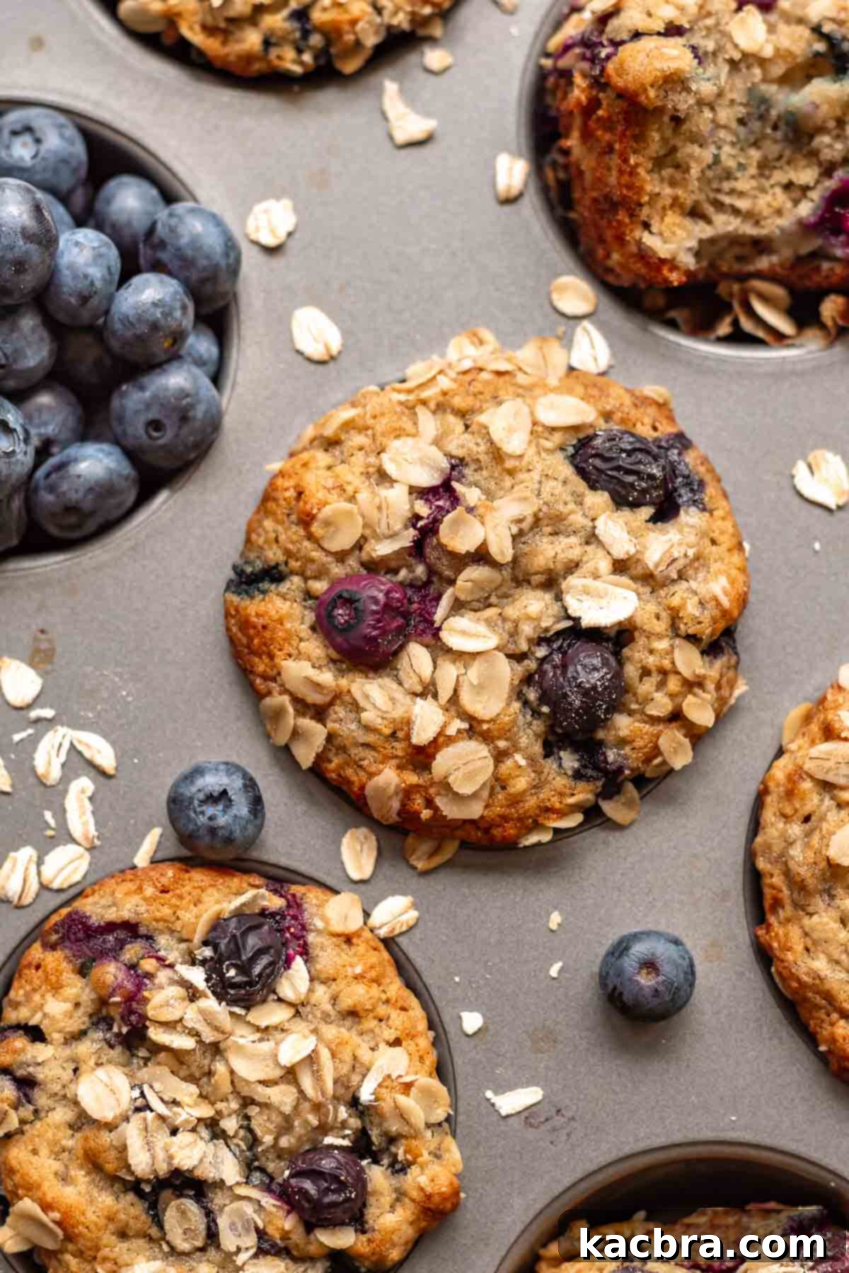 Sweet and Healthy Banana Blueberry Oatmeal Muffins 14 Freshly baked banana blueberry oatmeal muffins cooling in a muffin pan.