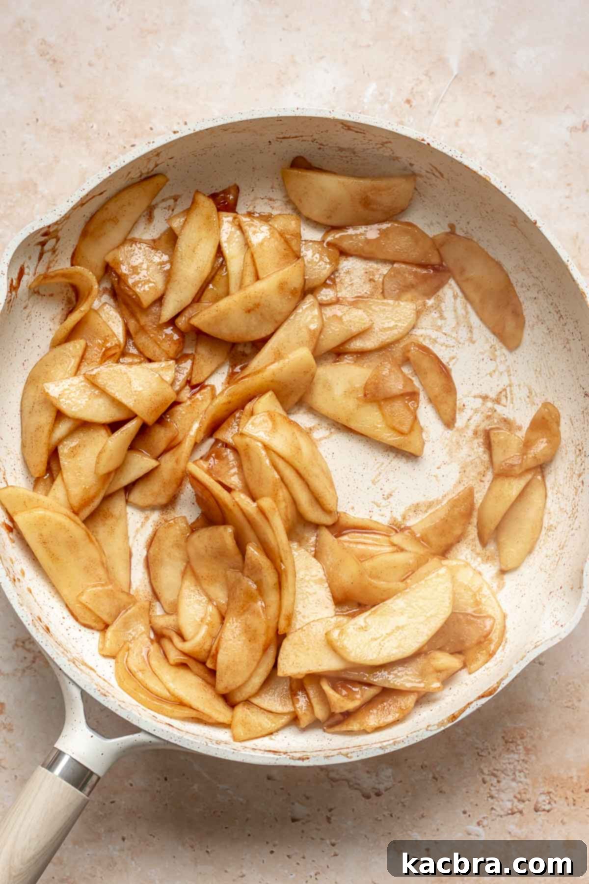 Cooked apple slices in a frying pan.