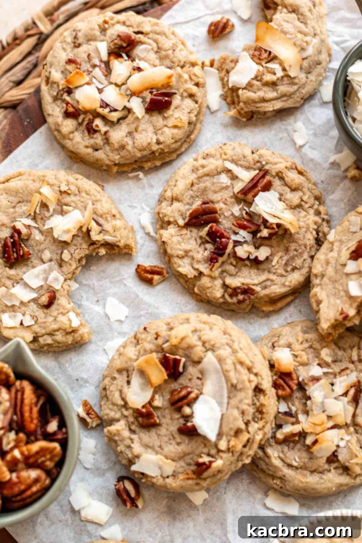 An inviting array of baked coconut pecan cookies cooling on parchment paper after coming out of the oven.