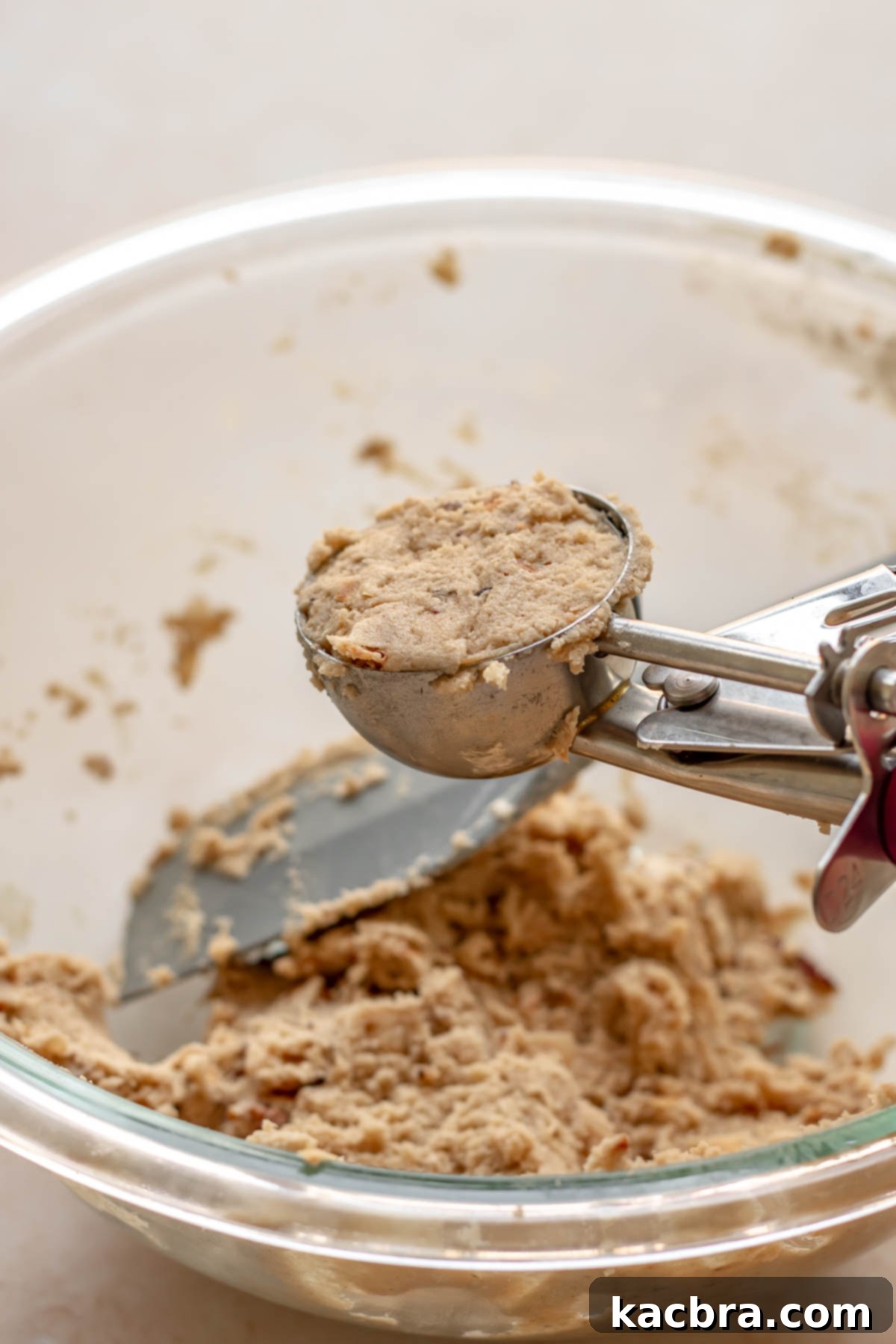 A 3-tablespoon cookie scoop filled with perfectly portioned cookie dough, ready for baking.