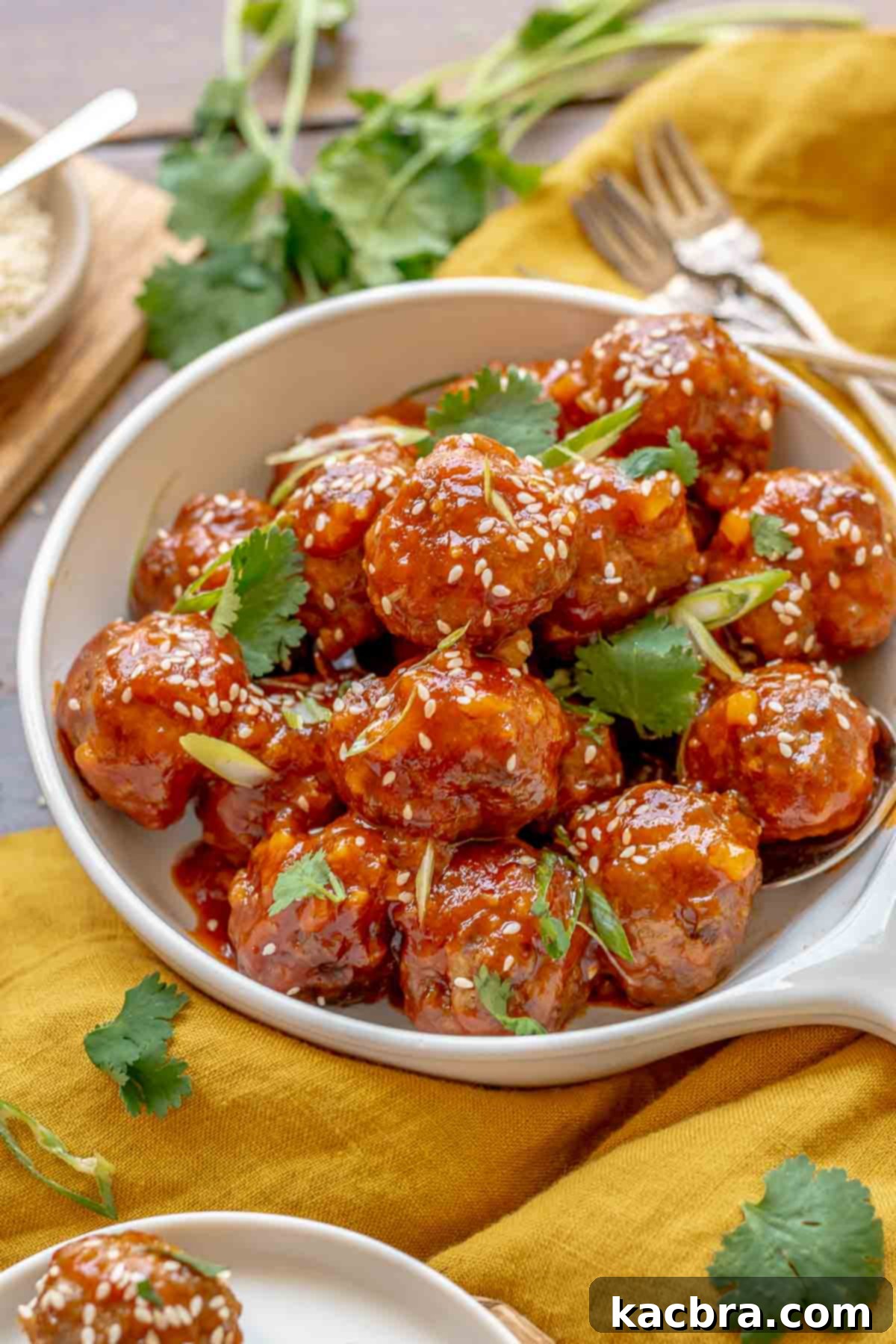 A garnished bowl of honey sriracha meatballs.