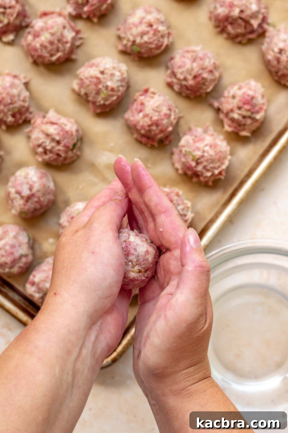 Hands Rolla. meatball in between the palms.