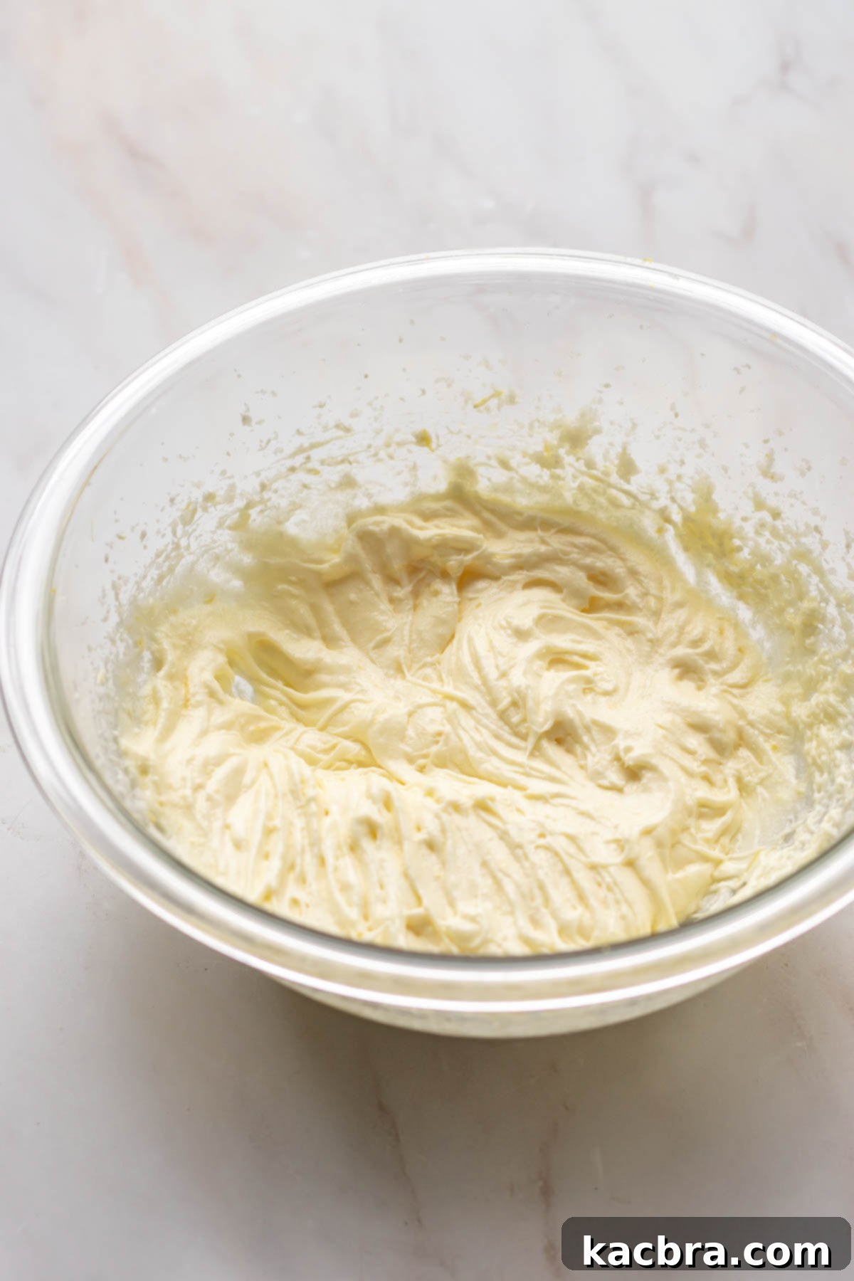 Adding eggs to the creamed butter and sugar mixture, ready to be beaten.