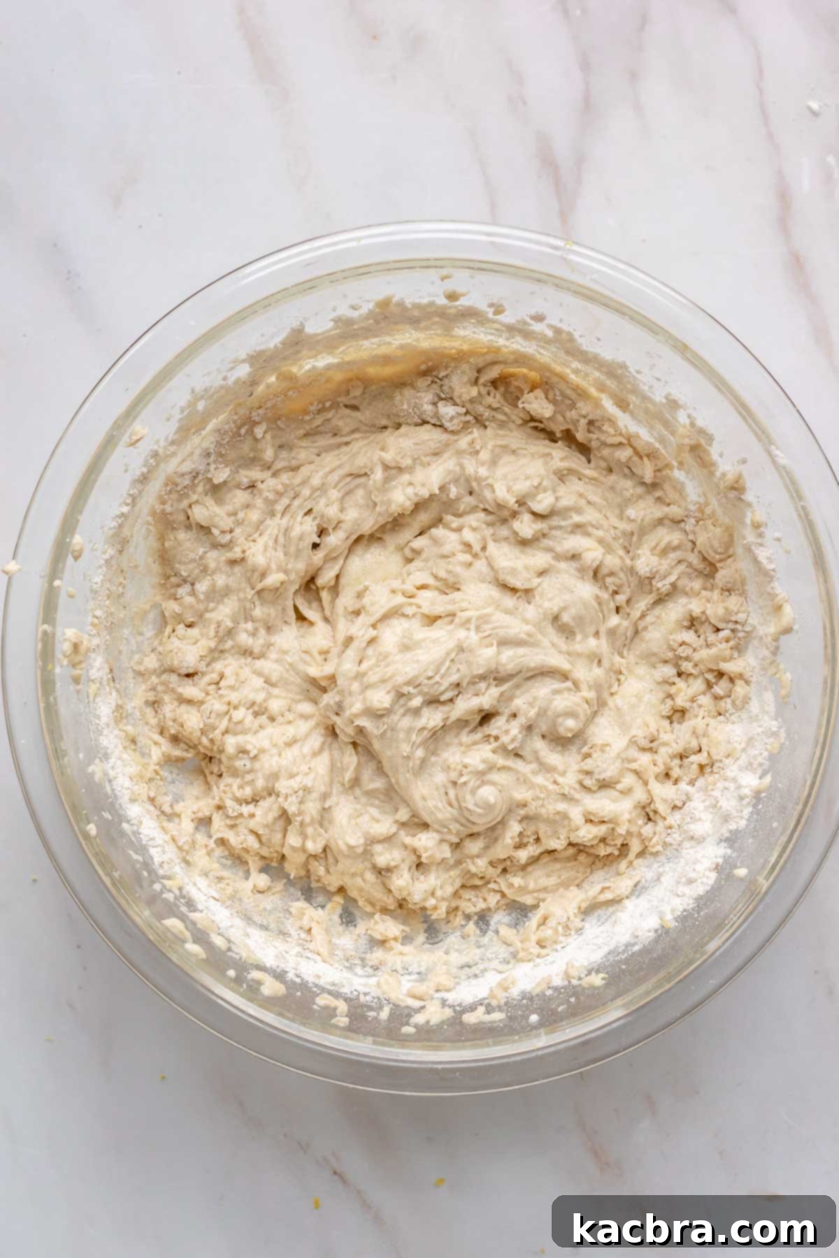 Partially mixed cake batter with some flour streaks still visible.