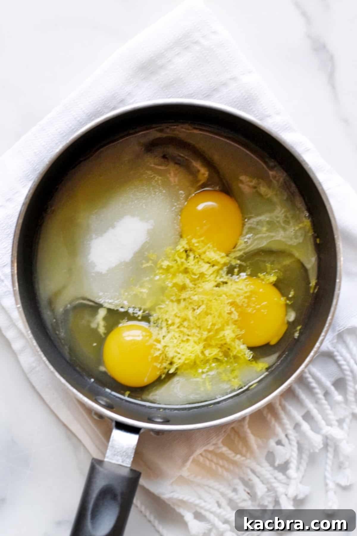 All the vibrant ingredients for lemon curd (sugar, eggs, lemon juice, zest) artfully arranged in a saucepan, poised for whisking and cooking.