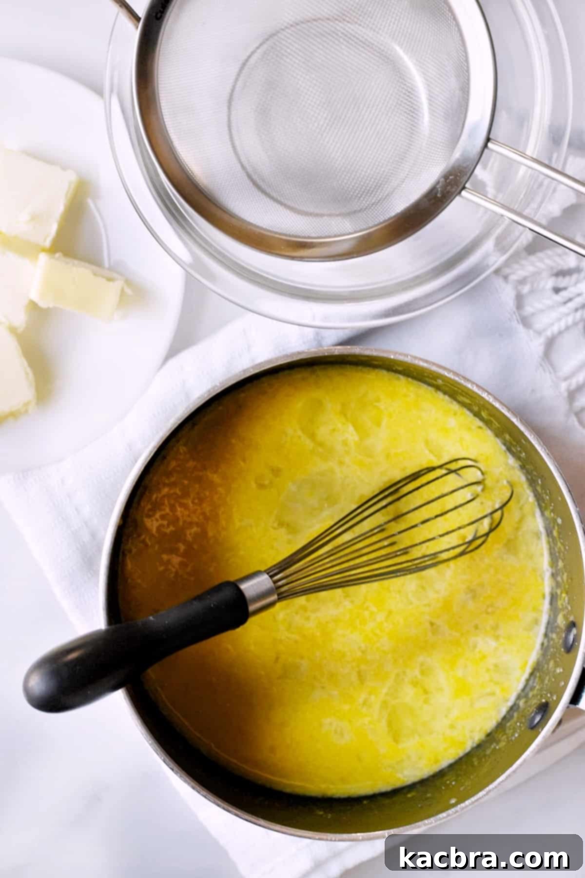 The lemon curd mixture, now thoroughly whisked, resting in a saucepan before being placed on the stove, showing its smooth, uniform consistency.