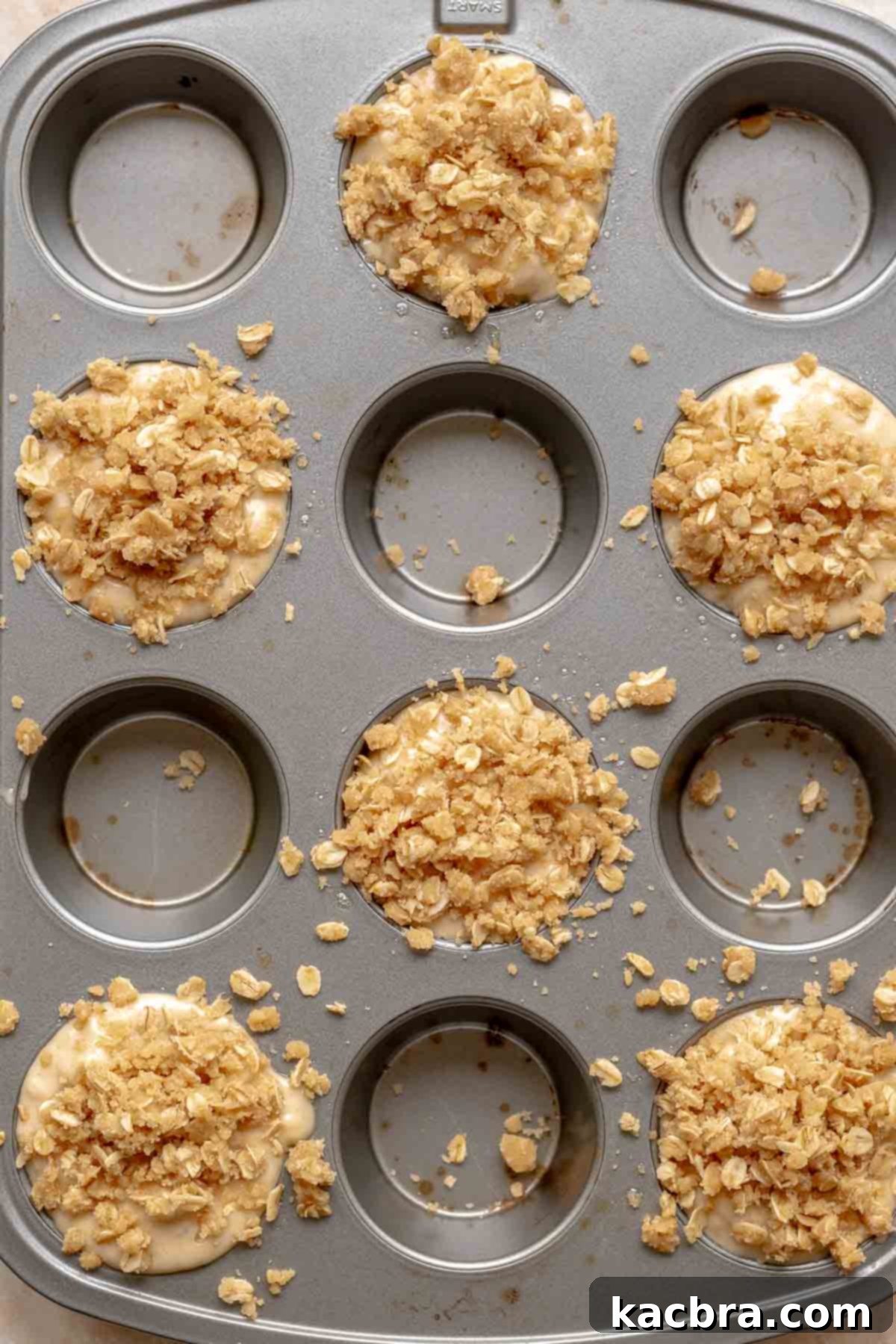 Streusel topping generously sprinkled on top of muffin batter before baking.