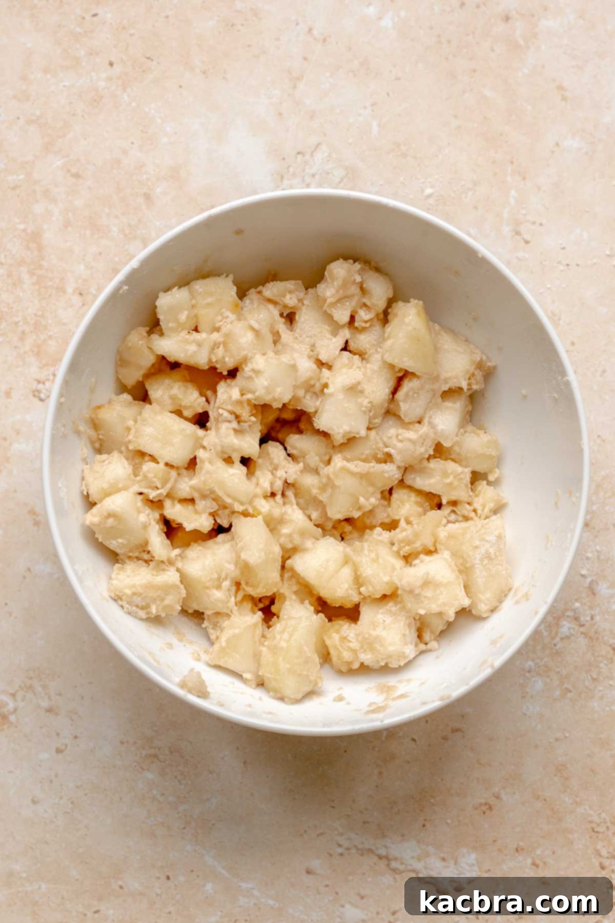 Pear chunks tossed with flour in a bowl to prevent sinking.