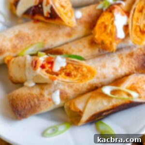 Buffalo chicken taquitos on a platter drizzled with ranch.
