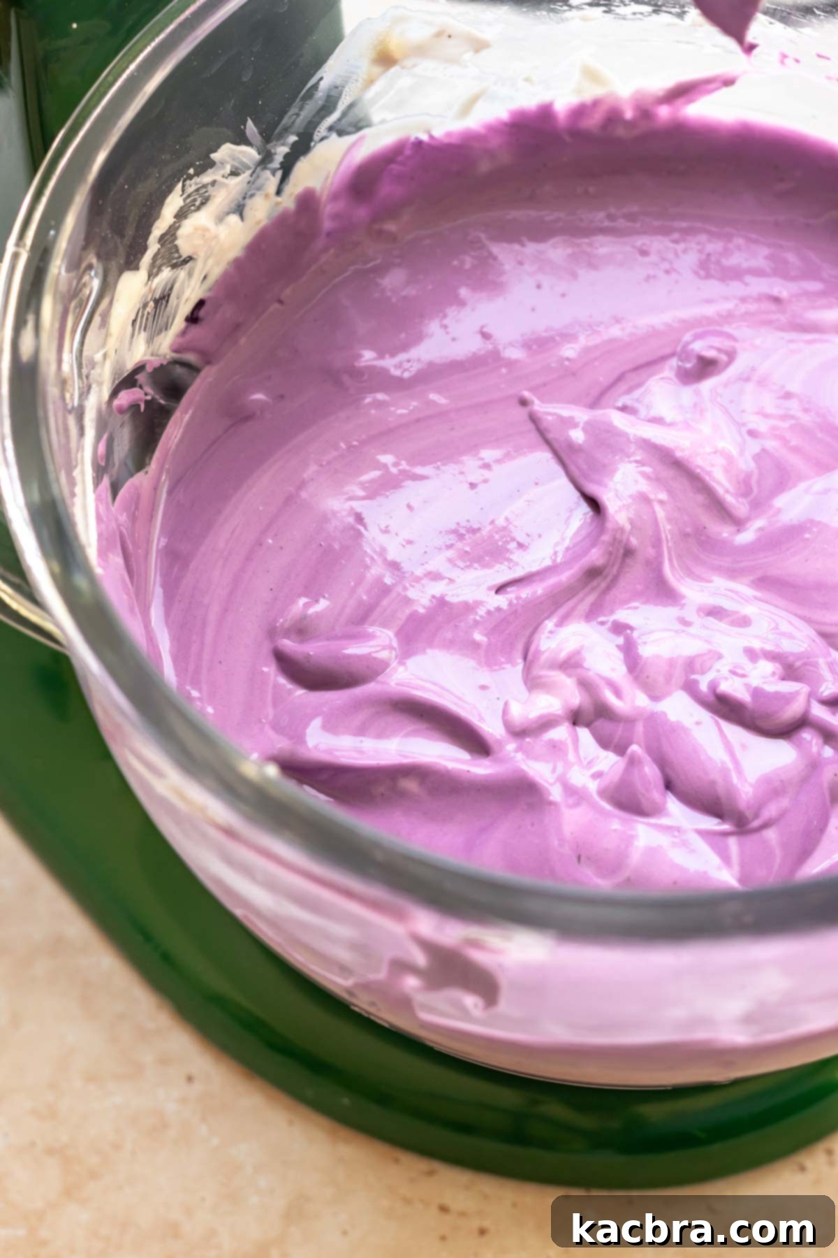 Purple use cheesecake batter in a stand mixer bowl.