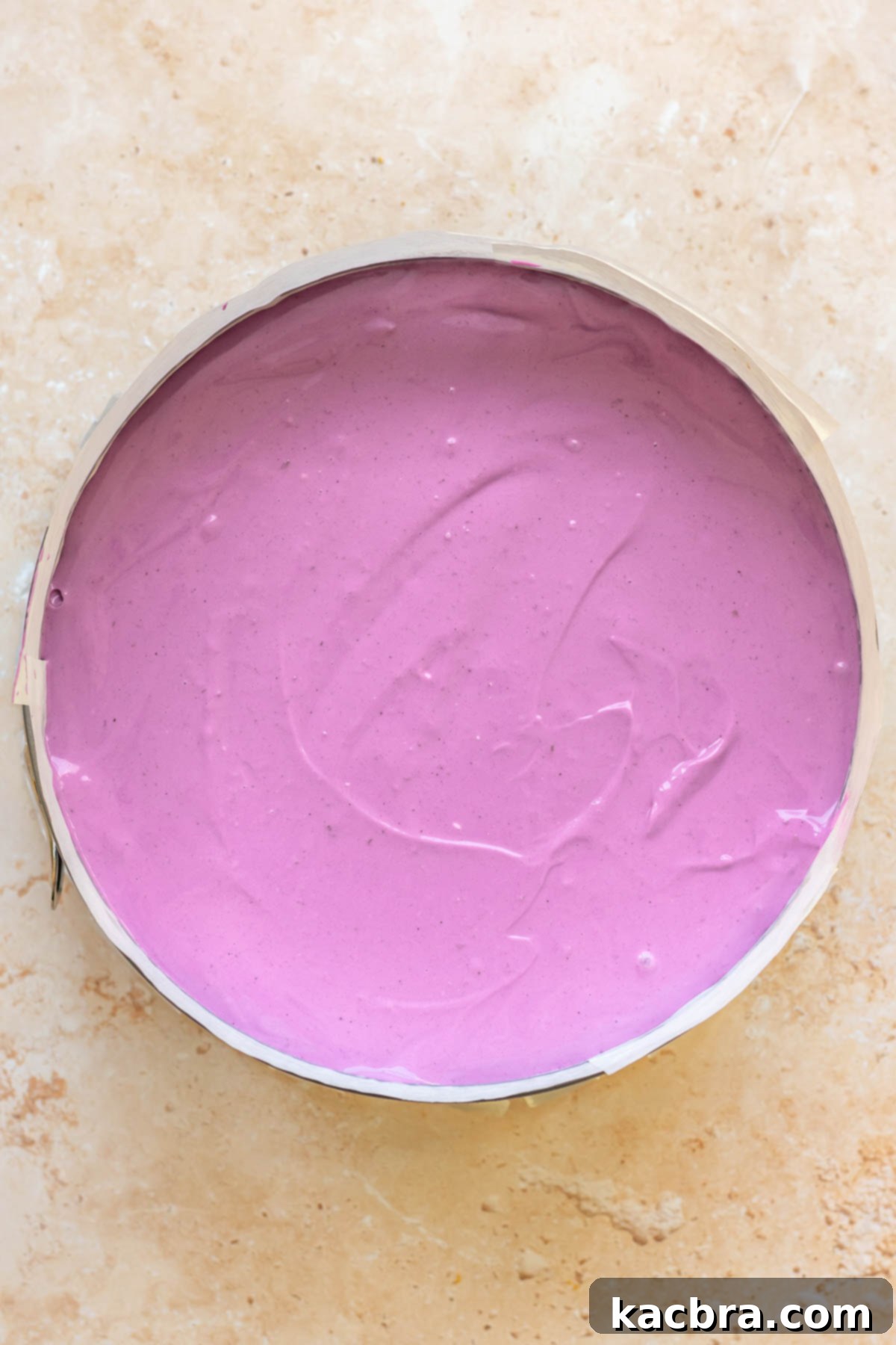 Ube batter spread into a prepared springform pan.