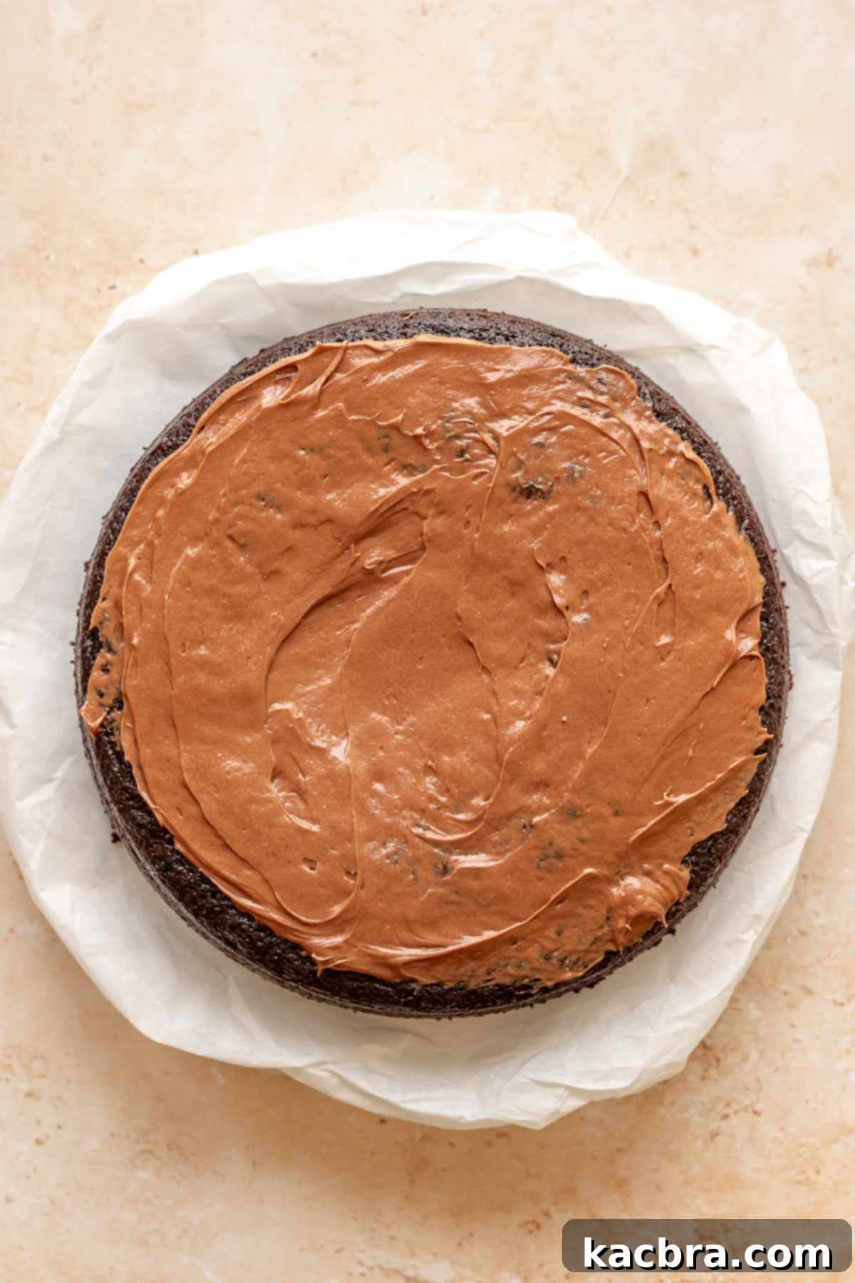 Chocolate frosting spread onto chocolate cake.