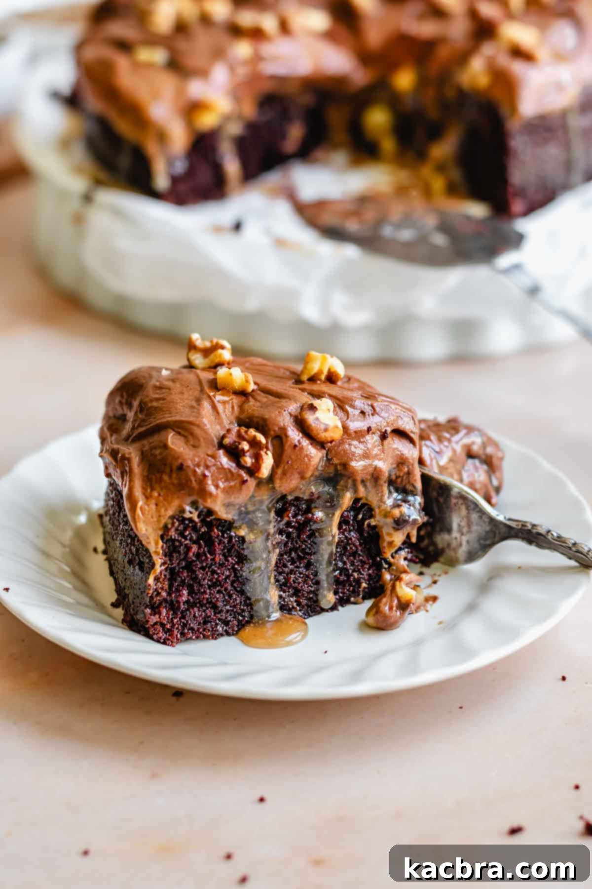 A perfectly portioned slice of chocolate walnut cake on a white plate.
