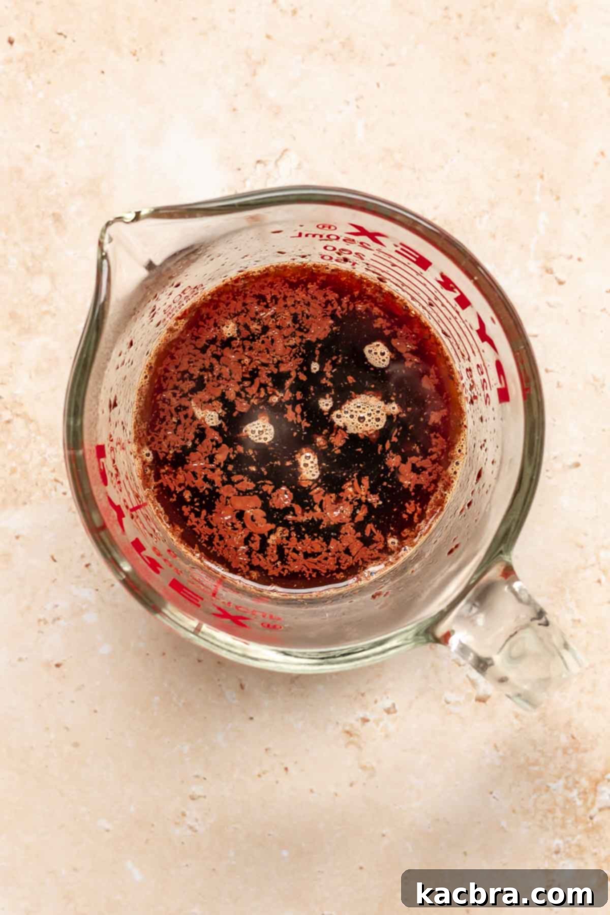 Coffee and chopped chocolate in a liquid measuring cup.