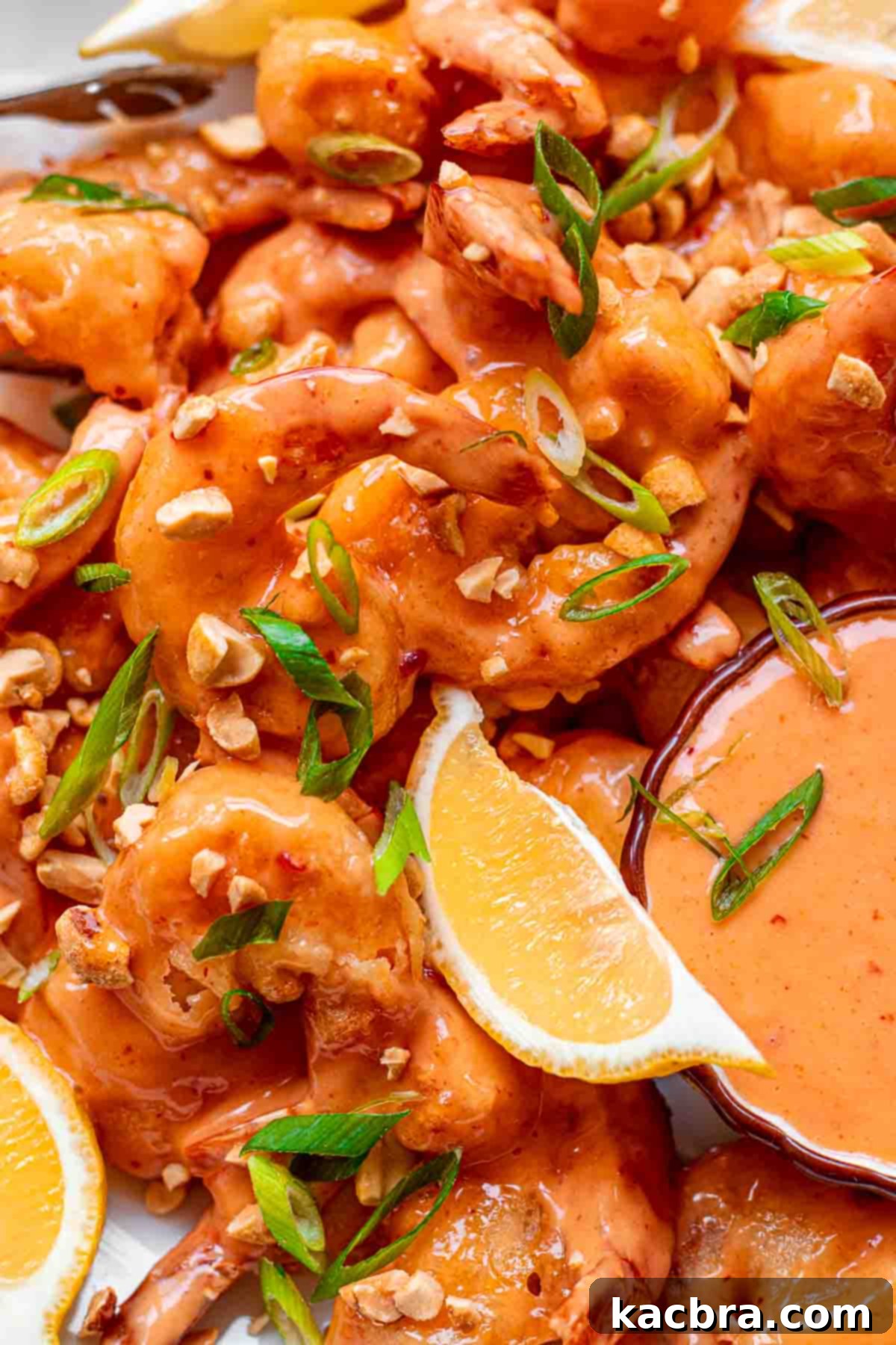 Boom boom shrimp plated on a platter with lemon slices.