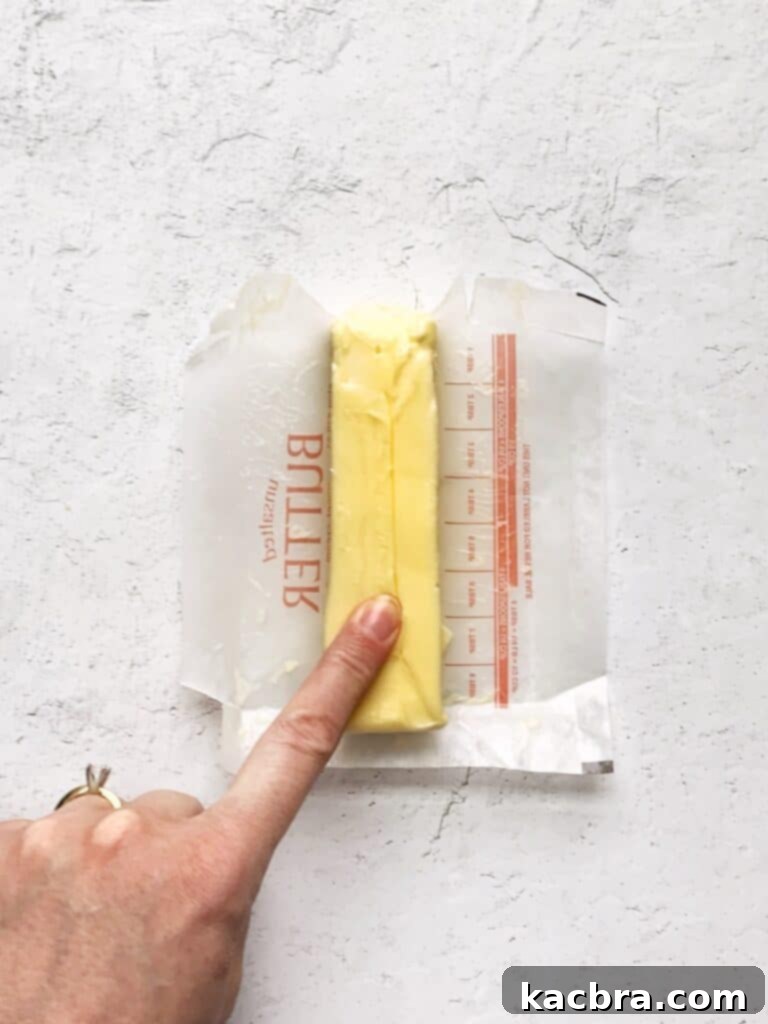 Decoding Room Temperature for Better Butter 4 A finger pushing in to a stick of room temperature butter.